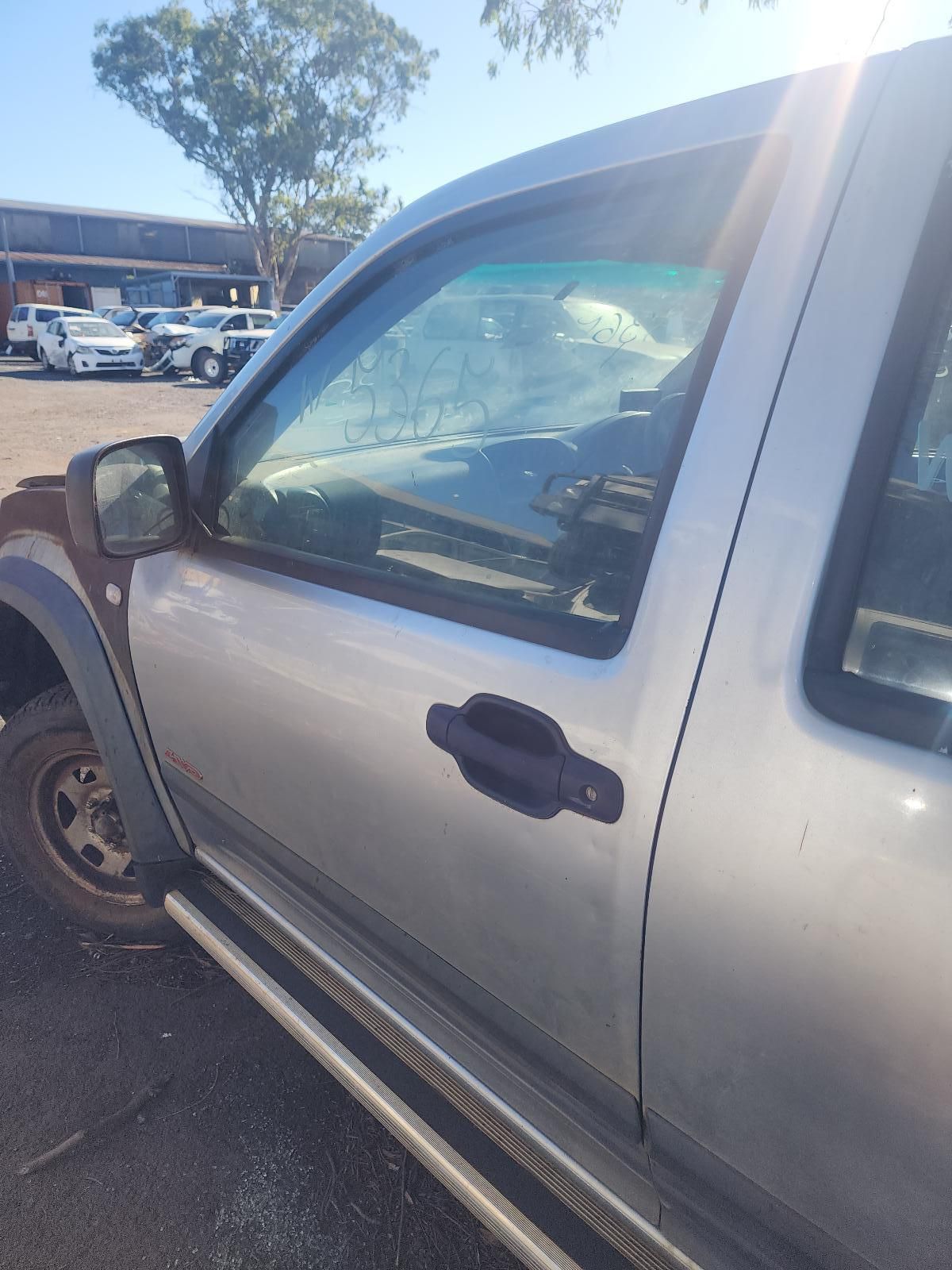 Silver Pickup Truck Parked Outdoors with A Dark Side Mirror and Step Bar Visible — South West 4WD Wreckers In Harristown, QLD