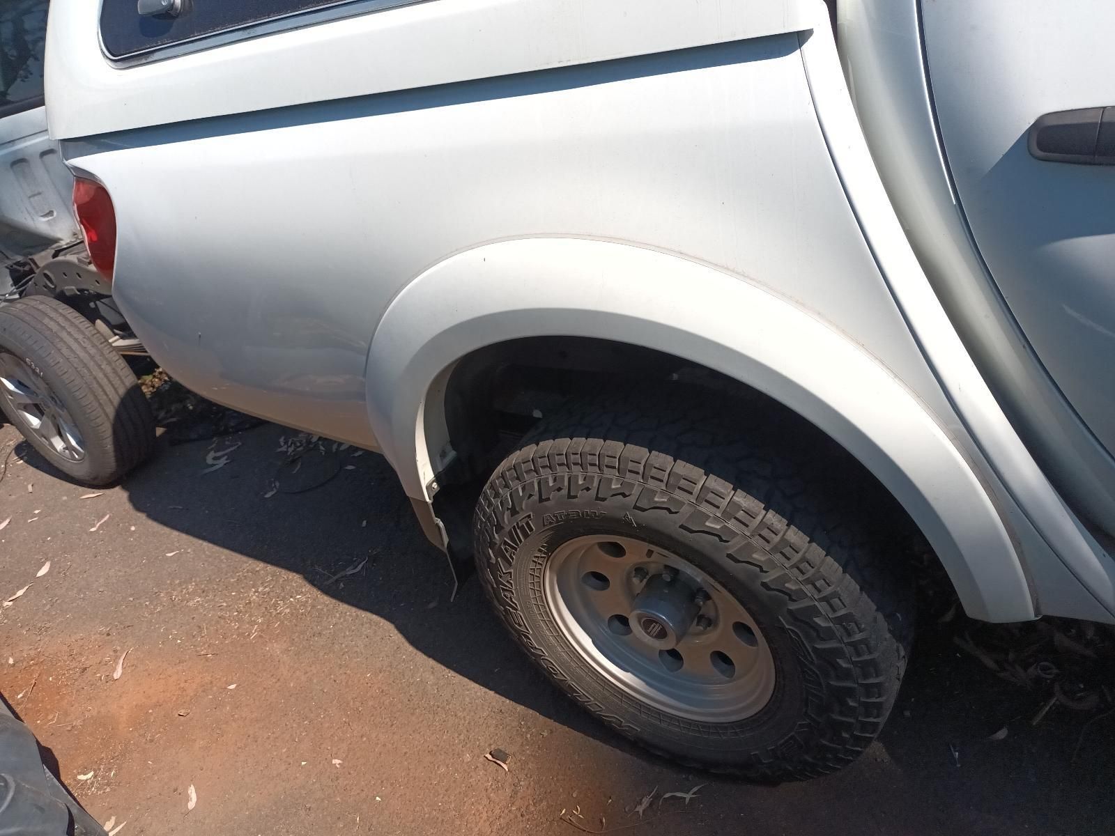 Silver Pickup Truck Rear Wheel and Fender Close-Up on A Sunlit Road — South West 4WD Wreckers In Harristown, QLD