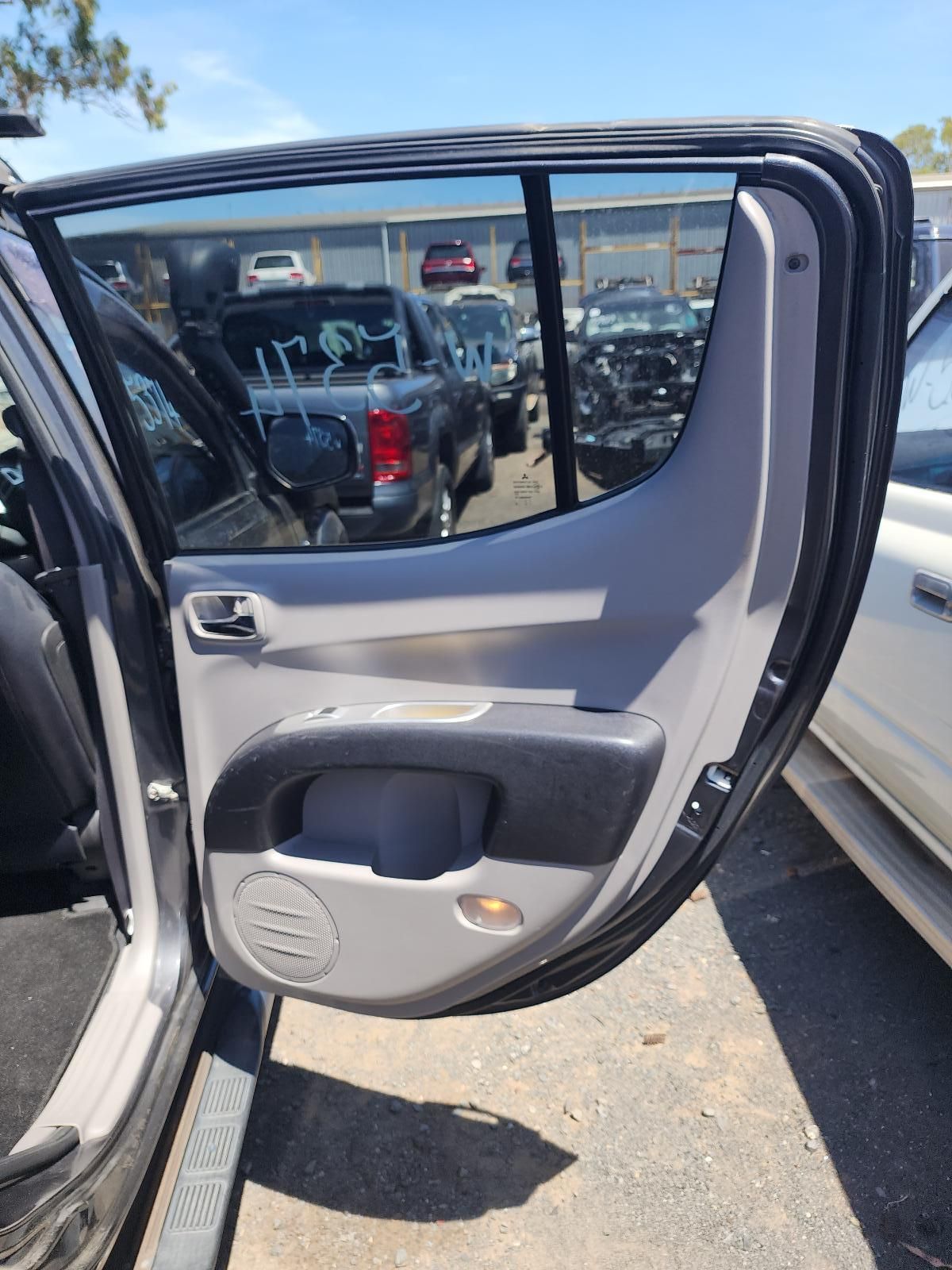 Open Car Door With Gray Interior Panel in a Parking Lot — South West 4WD Wreckers In Harristown, QLD