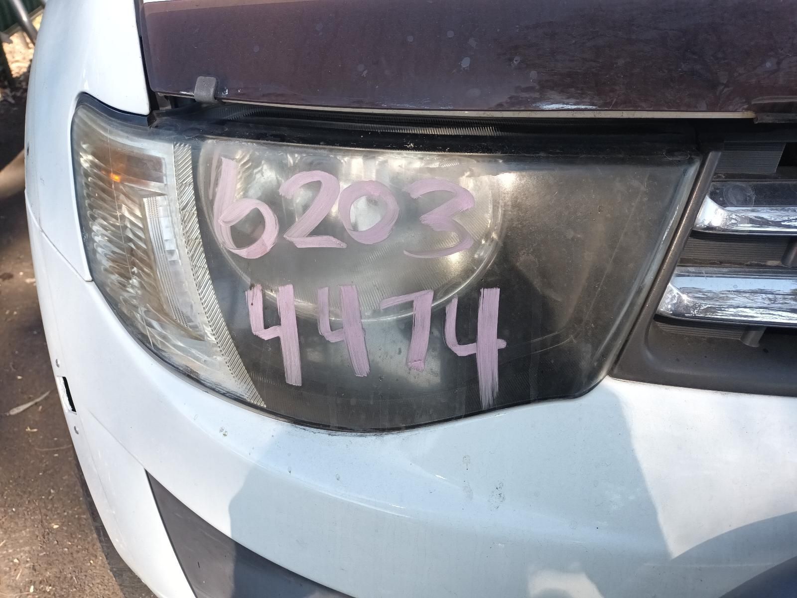 Close-Up of A White Car’s Front Headlight with Pink Marker Writing on The Lens — South West 4WD Wreckers In Harristown, QLD