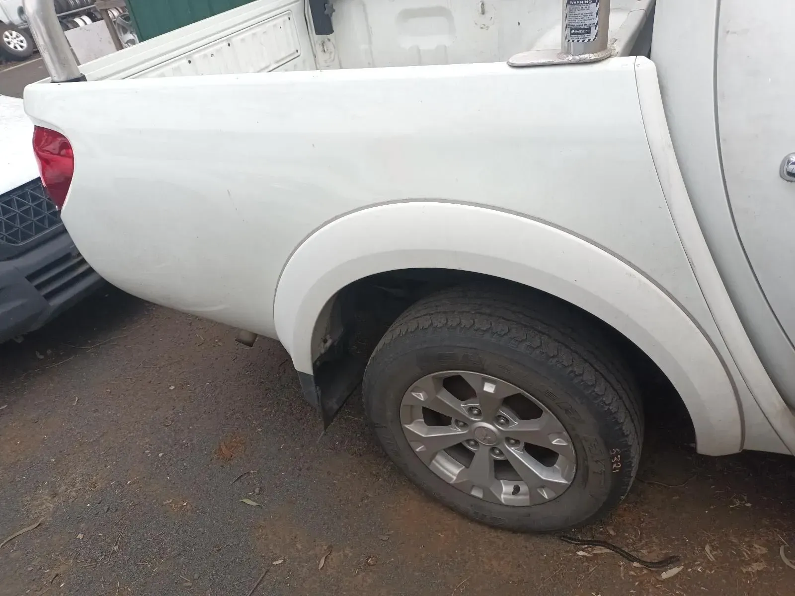 White Pickup Truck Rear Fender With Tyre, Parked Outdoors — South West 4WD Wreckers In Harristown, QLD