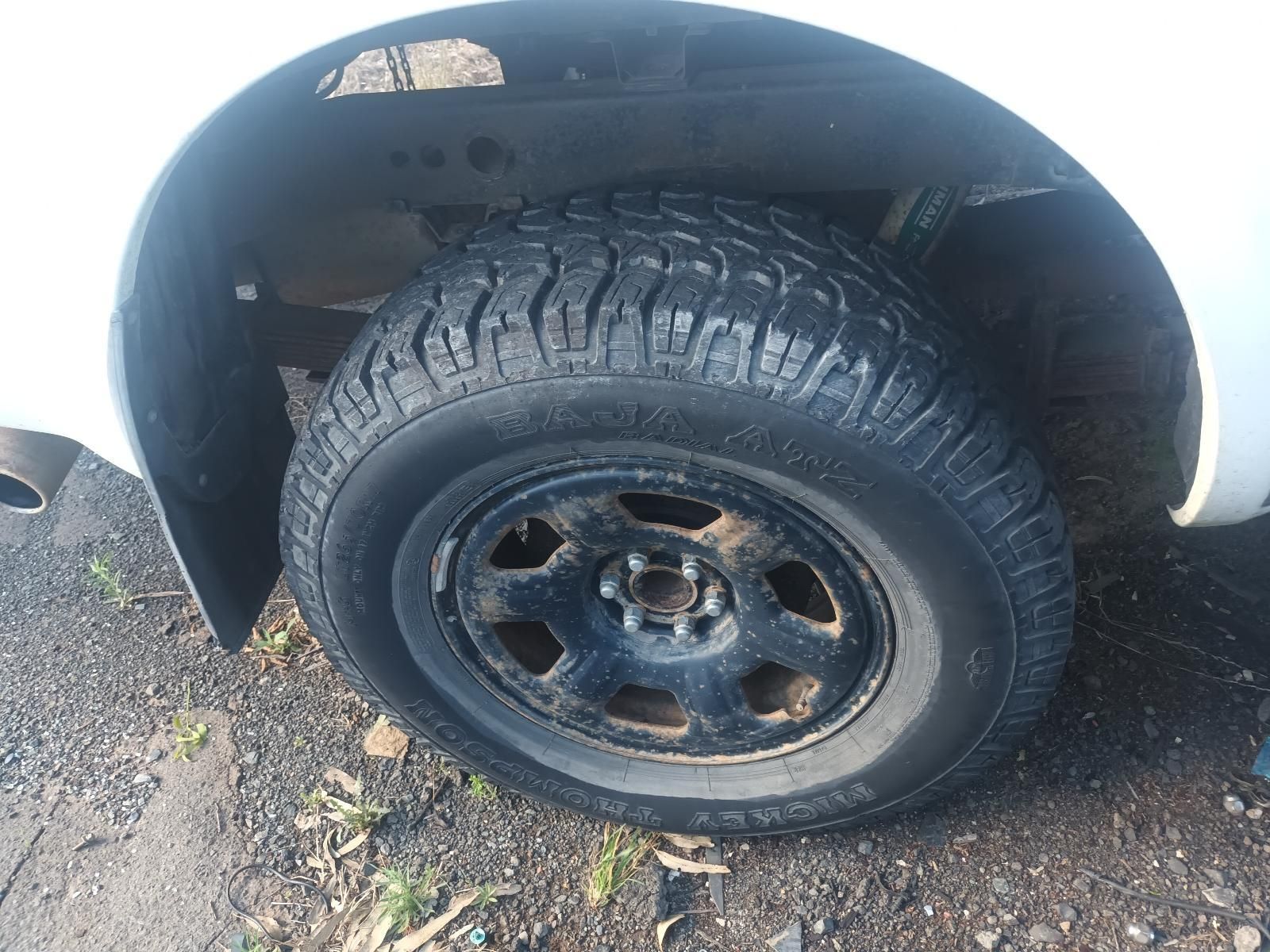 Close-Up of A Black Tyre and Wheel on A White Vehicle, Parked on Gravel — South West 4WD Wreckers In Harristown, QLD