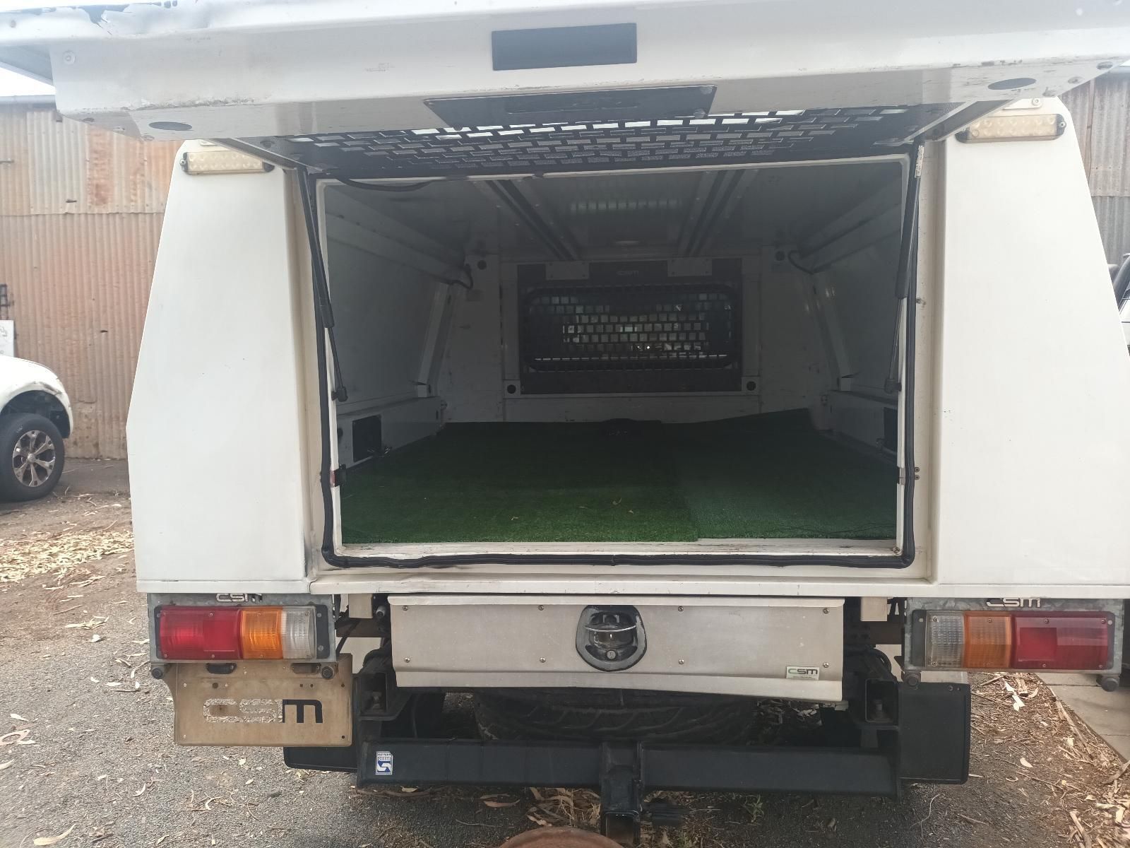 Open Van Rear with Cargo Area Lined in Green Turf and A Metal Rack Inside — South West 4WD Wreckers In Harristown, QLD