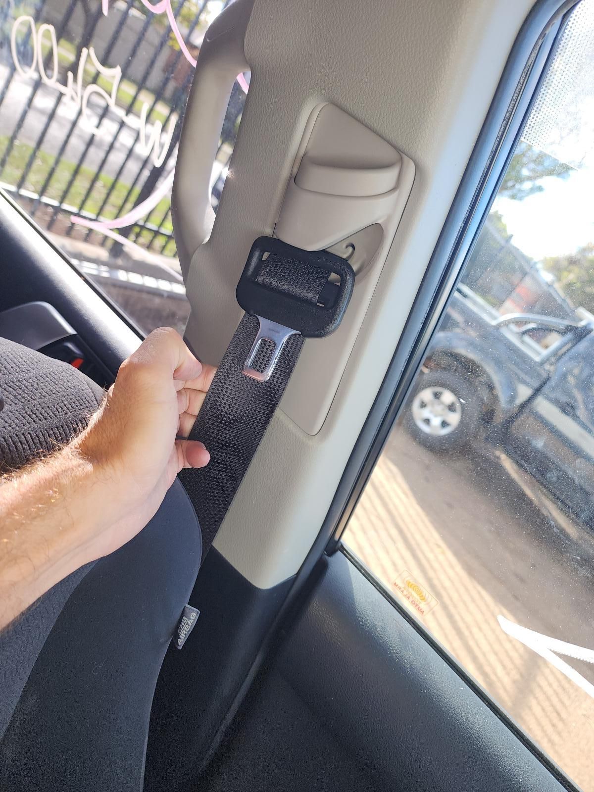 Hand Holding a Seat Belt Strap Inside a Car — South West 4WD Wreckers In Harristown, QLD
