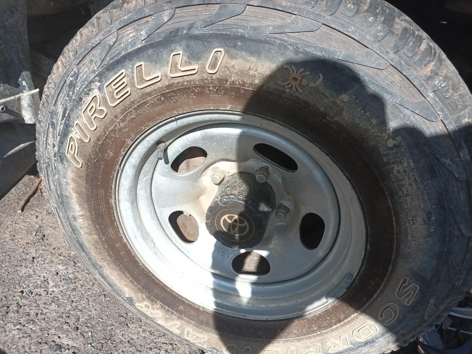 Close-Up of A Worn Pirelli Tyre and Steel Wheel on Gravel — South West 4WD Wreckers In Harristown, QLD