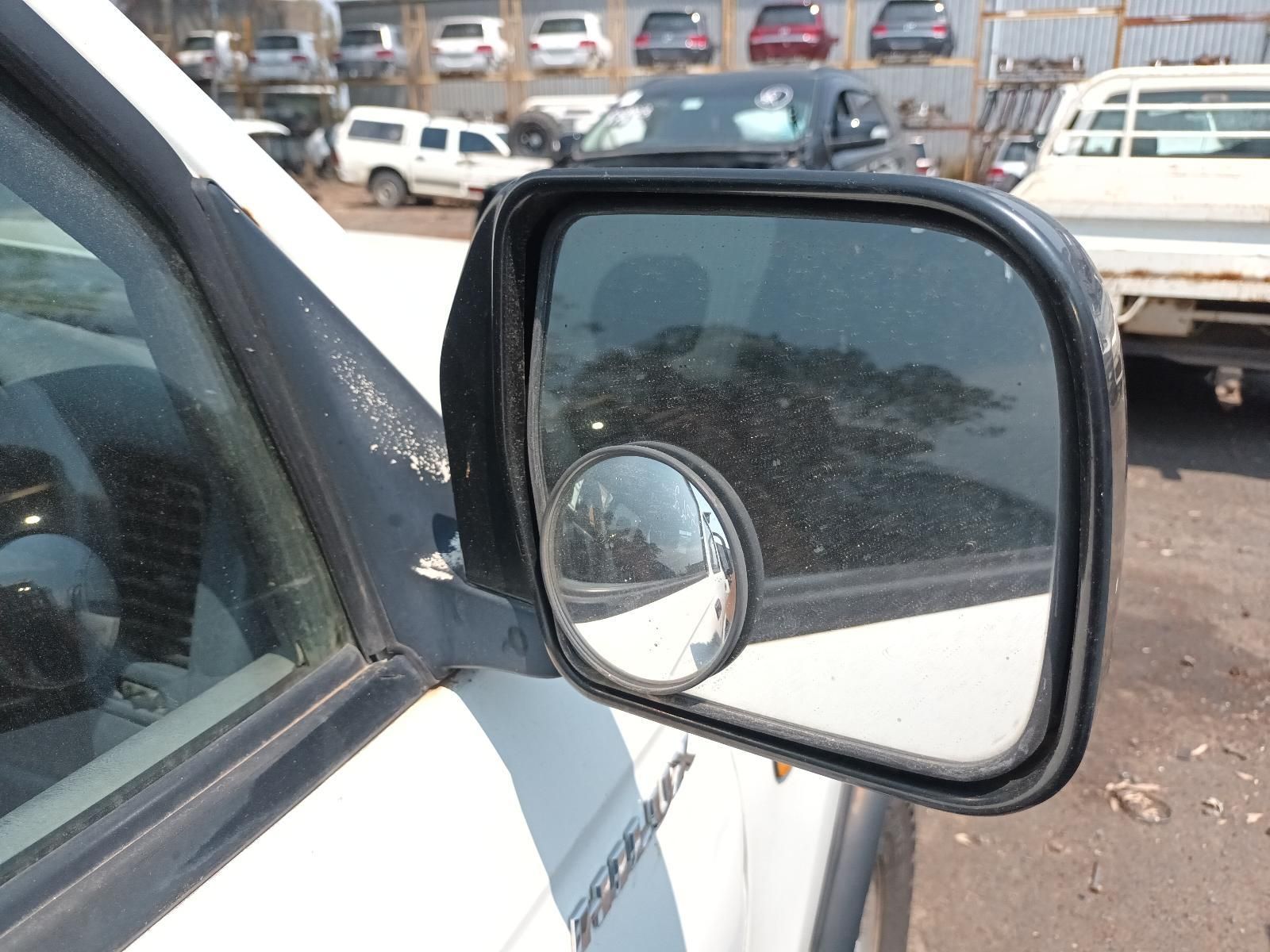 Side View Mirror on A White Car, Reflecting a Parking Lot with Parked Vehicles — South West 4WD Wreckers In Harristown, QLD