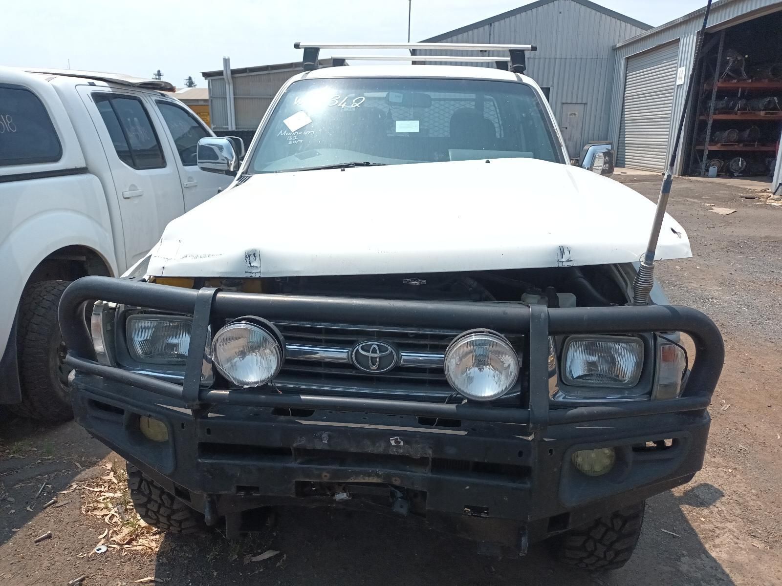 White Utility Truck with A Heavy Front Bull Bar Parked on A Gravel Lot — South West 4WD Wreckers In Harristown, QLD