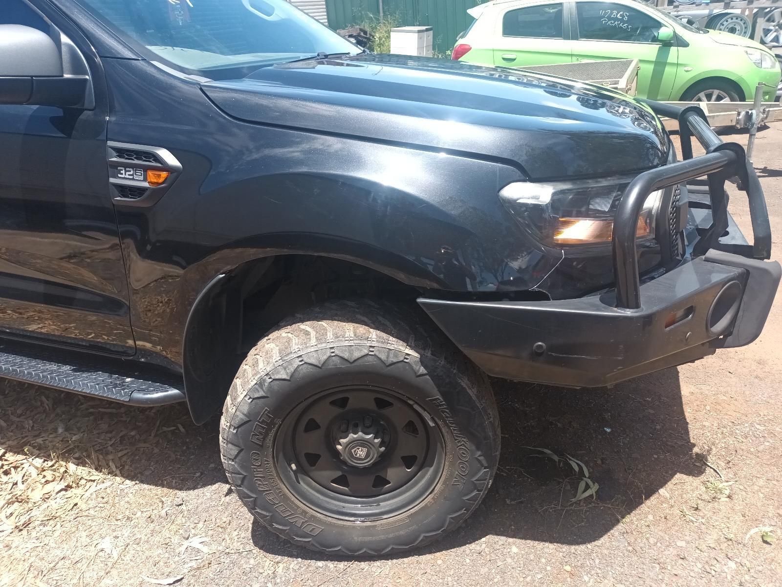 Black Pickup Truck with Heavy-Duty Front Bumper Parked on A Dirt Lot, Side View — South West 4WD Wreckers In Harristown, QLD