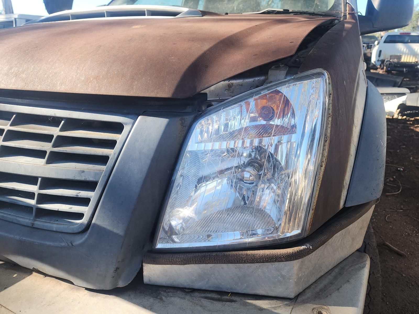 The front of a brown vehicle with a dented hood and cracked headlight — South West 4WD Wreckers In Harristown, QLD