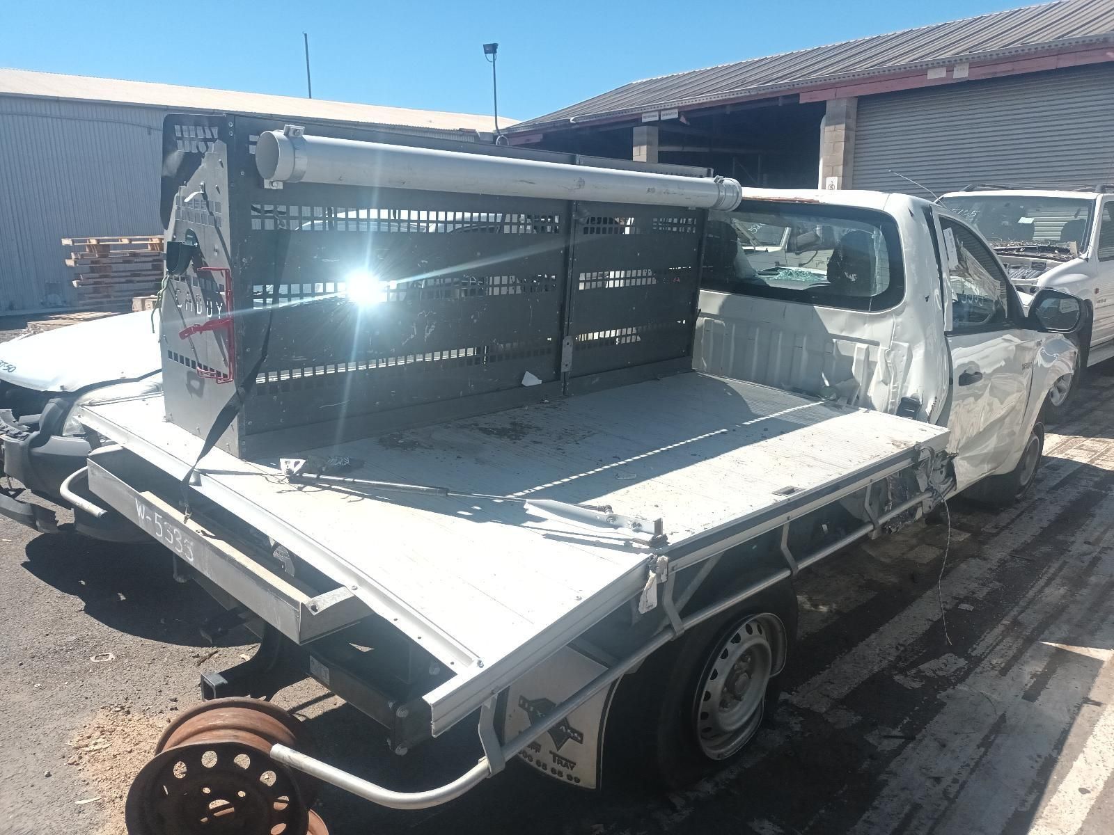 White Utility Truck with A Flatbed Carrying a Large Black Metal Frame — South West 4WD Wreckers In Harristown, QLD