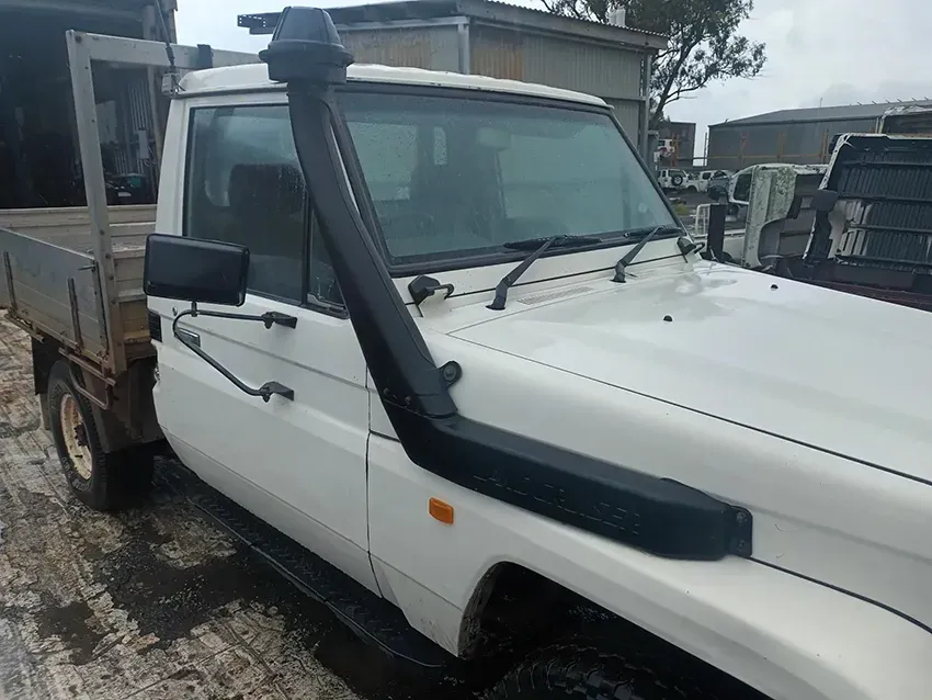 A White Truck With a Snorkel on the Hood is Parked in the Snow — South West 4WD Wreckers In Brisbane, QLD