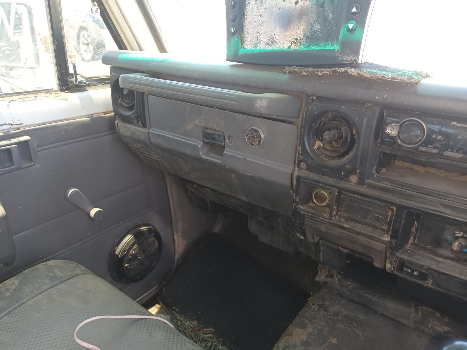 Old, Dusty Car Interior with Worn Dashboard, Passenger Seat, and Green Sun Visor — South West 4WD Wreckers In Harristown, QLD