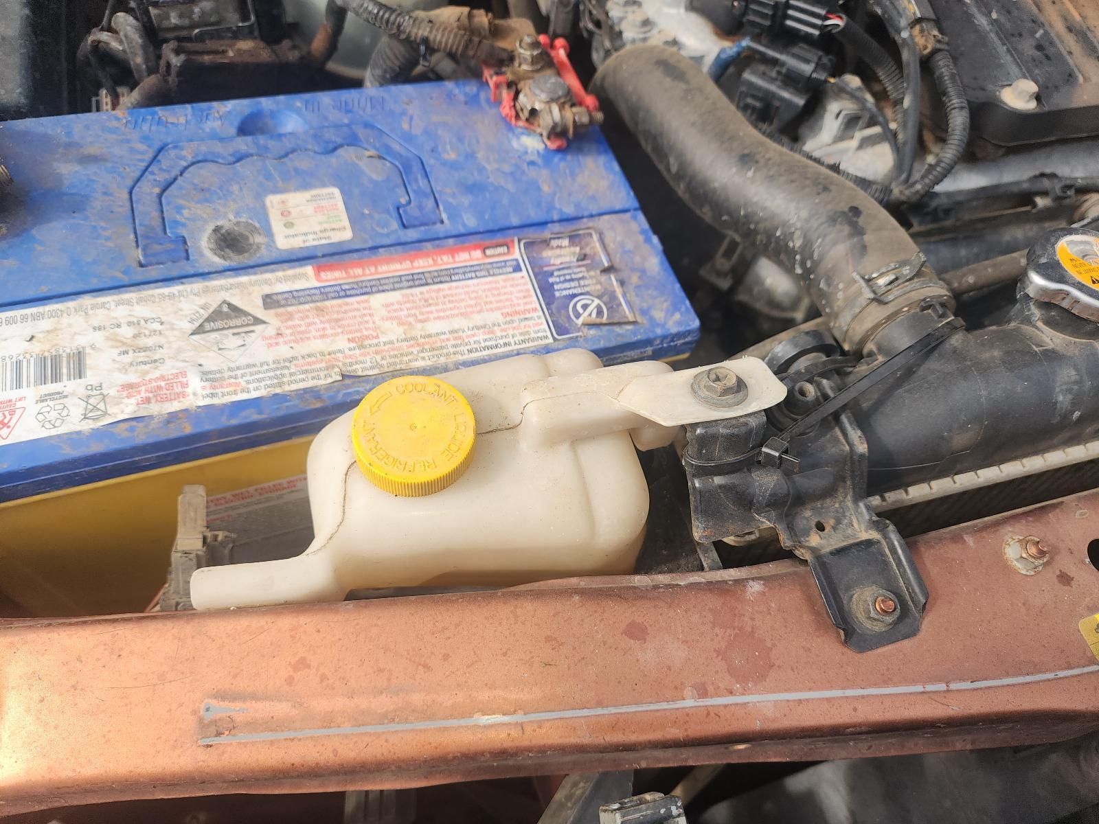 Car Engine Bay With Blue Battery and White Coolant — South West 4WD Wreckers In Harristown, QLD