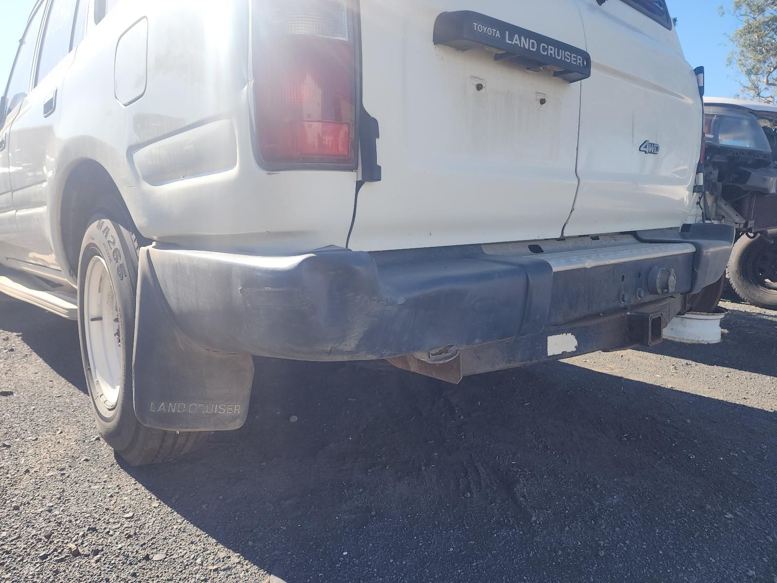 Damaged White Suv Rear Bumper and Tailgate in A Parking Lot — South West 4WD Wreckers In Harristown, QLD