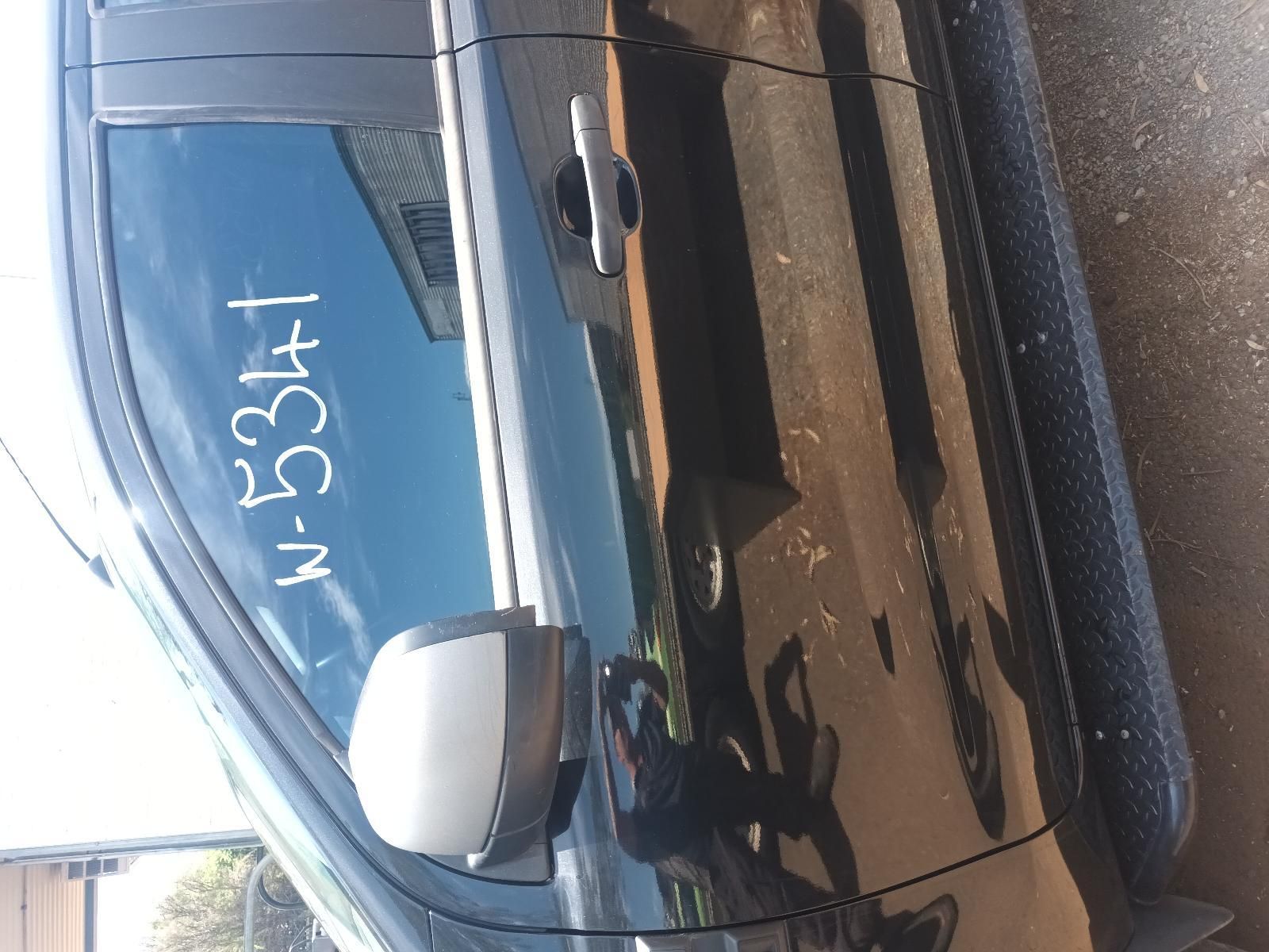 Black Car Parked on Wet Pavement with A Blue License Plate, Viewed from The Side — South West 4WD Wreckers In Harristown, QLD