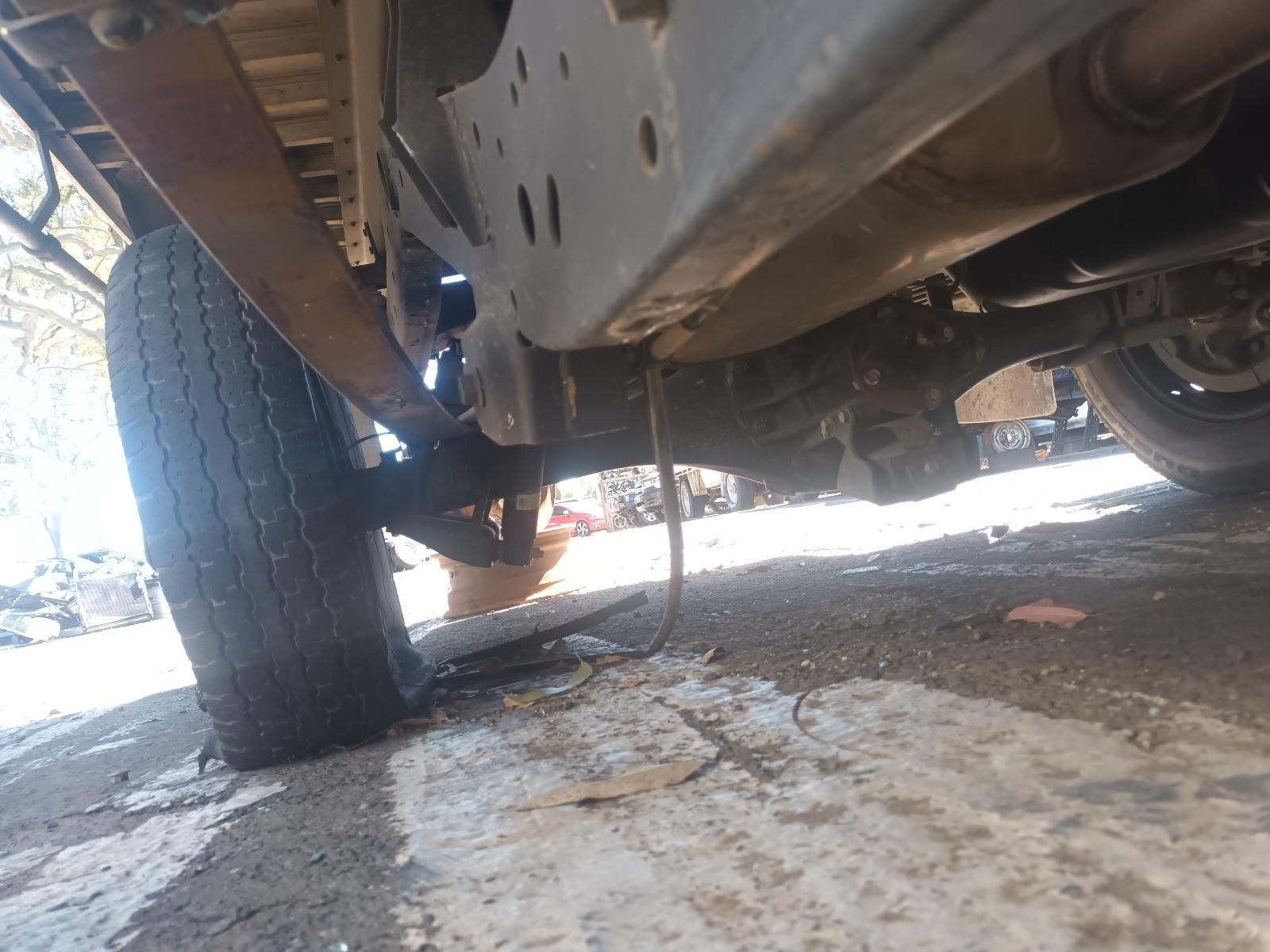 Underneath a Vehicle, Showing the Undercarriage and A Wheel on A Wet Road — South West 4WD Wreckers In Harristown, QLD