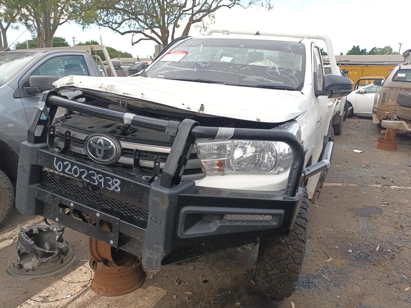 Damaged White Pickup Truck with A Bent Front Bumper in A Muddy Lot — South West 4WD Wreckers In Harristown, QLD