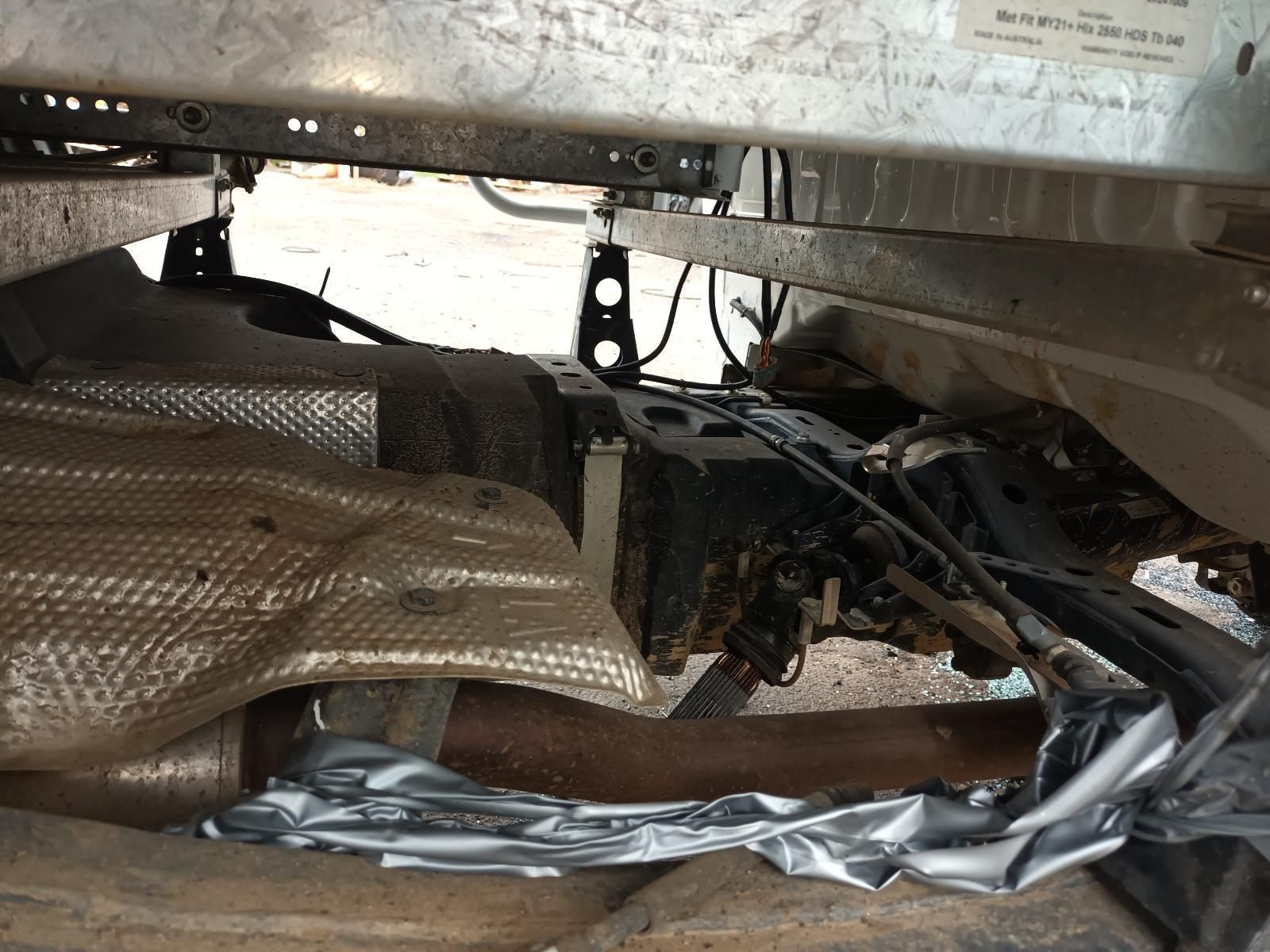 Damaged Car Undercarriage with Exposed Wiring, Heat Shielding, and Debris — South West 4WD Wreckers In Harristown, QLD