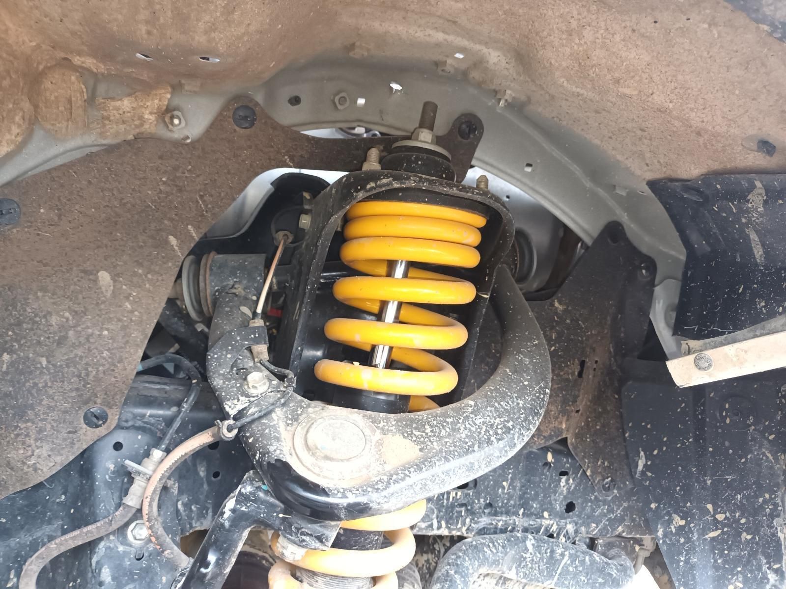 Car Suspension Strut with Bright Yellow Coil Spring Inside the Wheel Well — South West 4WD Wreckers In Harristown, QLD