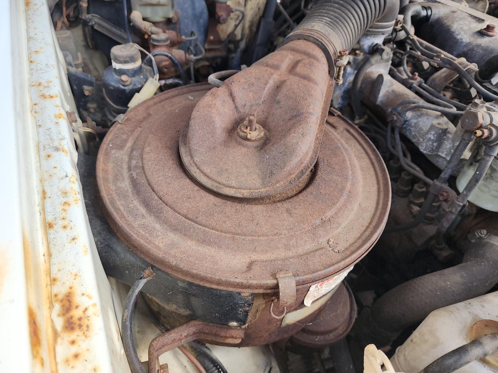 Rusty Round Air Filter Housing in an Engine Bay — South West 4WD Wreckers In Harristown, QLD