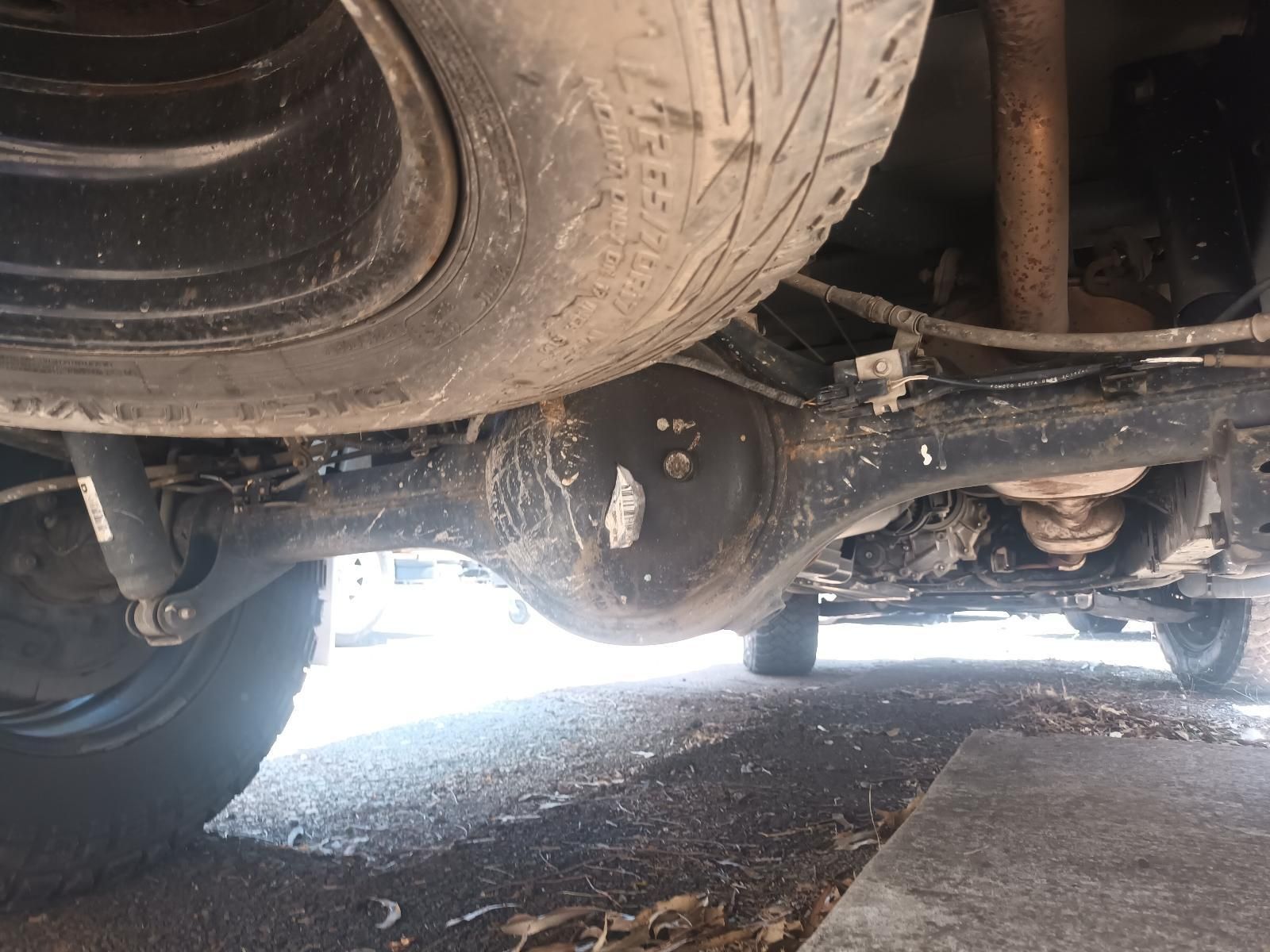 Underside of A Truck with A Tyre and Rear Axle on A Gravel Surface — South West 4WD Wreckers In Harristown, QLD