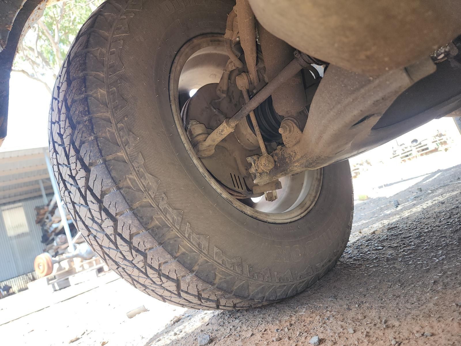 Close-up of a Car’s Rear Wheel and Undercarriage on a Gravel — South West 4WD Wreckers In Harristown, QLD