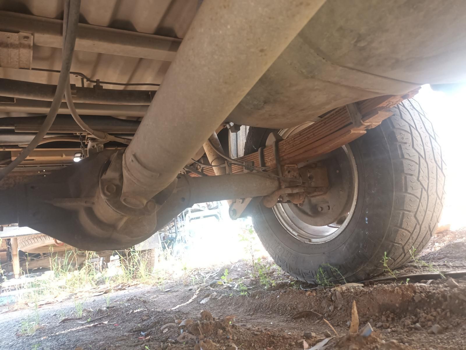 Undercarriage of A Vehicle with Exhaust Pipe and Rear Wheel on Rough Ground — South West 4WD Wreckers In Harristown, QLD