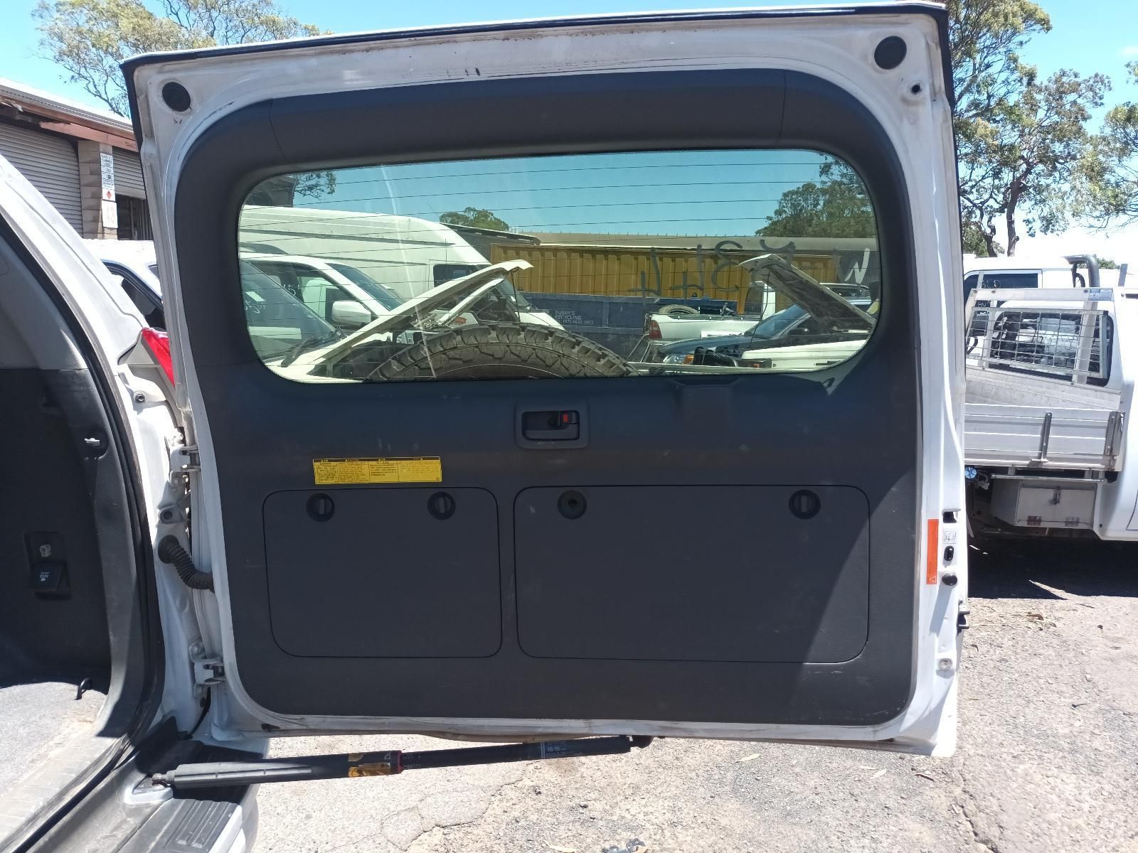 Open Rear of A White Van, Showing Cargo Area and Back Window in A Parking Lot — South West 4WD Wreckers In Harristown, QLD