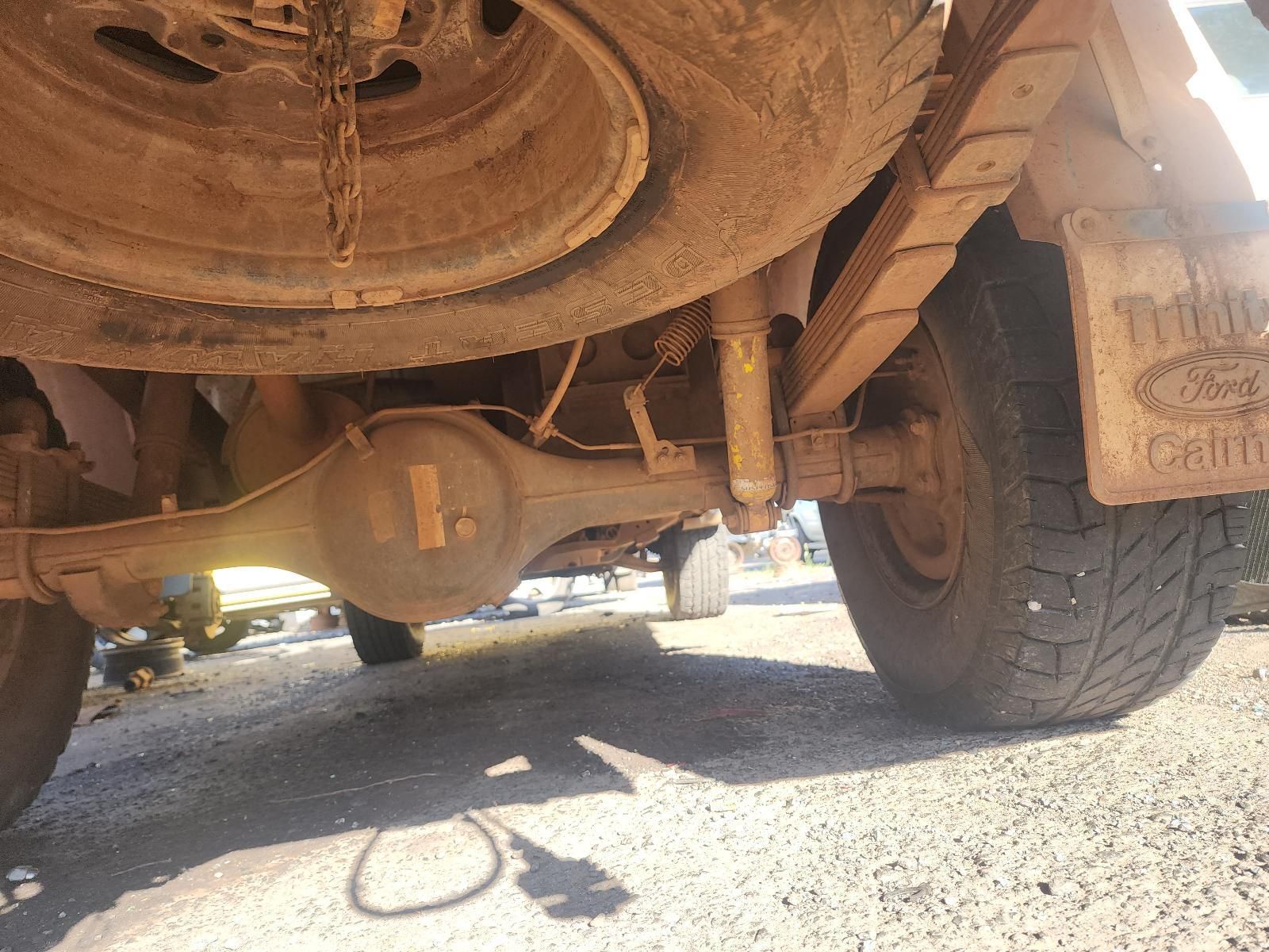Undercarriage of a Dusty Off-road Vehicle With a Large Tire on Gravel — South West 4WD Wreckers In Harristown, QLD
