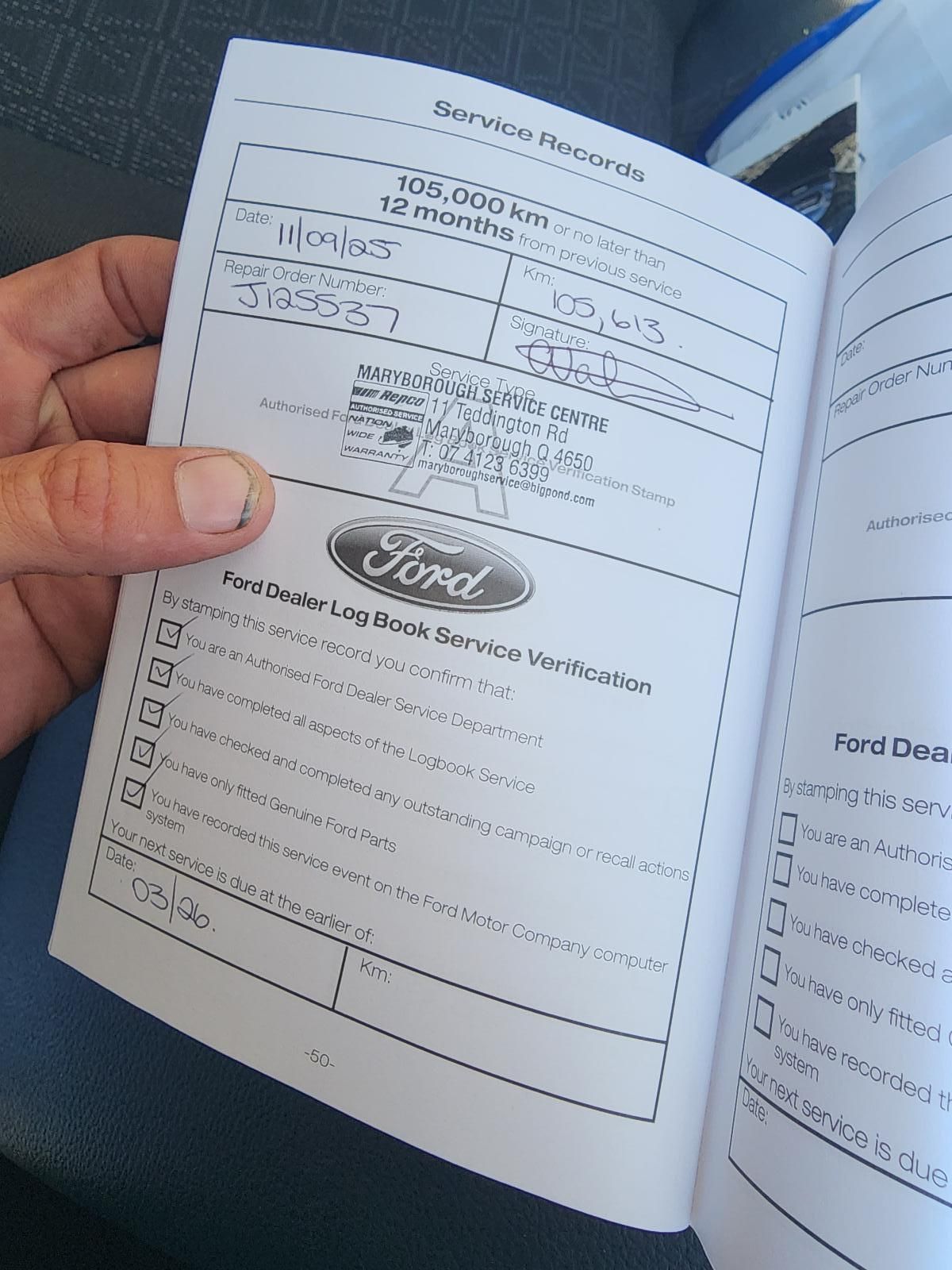 Hand Holding an Open Ford Vehicle Manual — South West 4WD Wreckers In Harristown, QLD