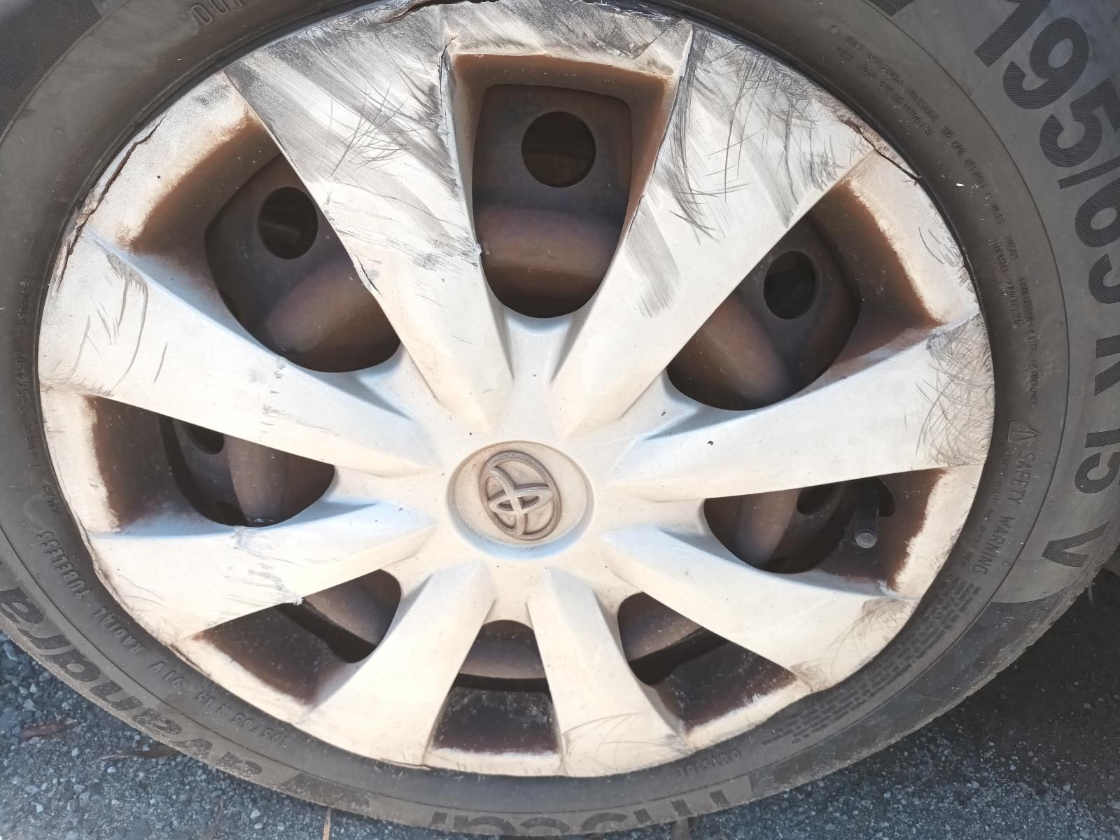 Close-Up of A Dusty Car Wheel with A White Hubcap and Black Tyre — South West 4WD Wreckers In Harristown, QLD