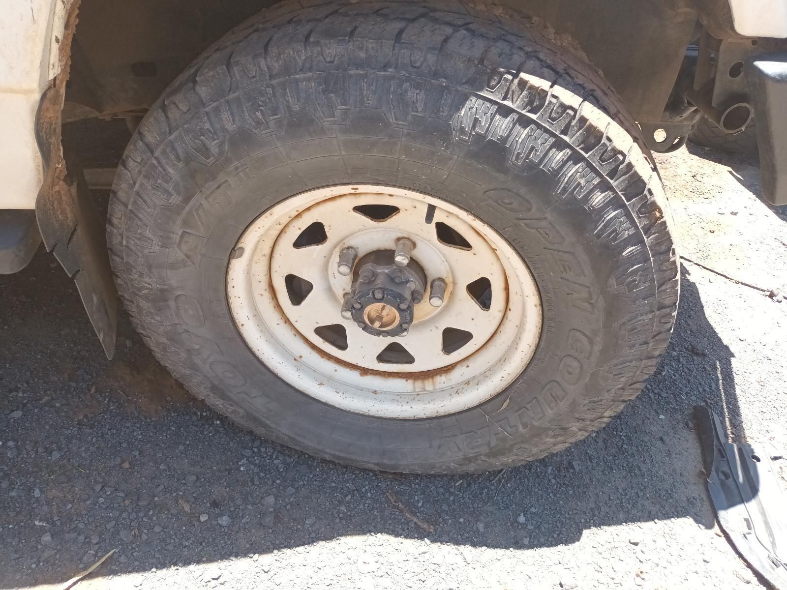 Close-Up of A Dusty Truck Tyre and White Wheel Rim on A Sunlit Roadside — South West 4WD Wreckers In Harristown, QLD