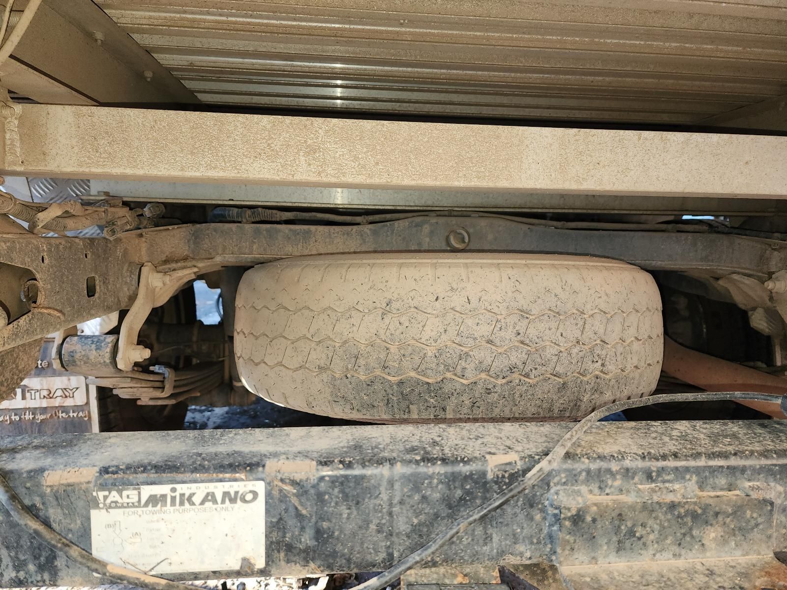 Dusty Spare Tire Mounted Under a Vehicle Chassis — South West 4WD Wreckers In Harristown, QLD