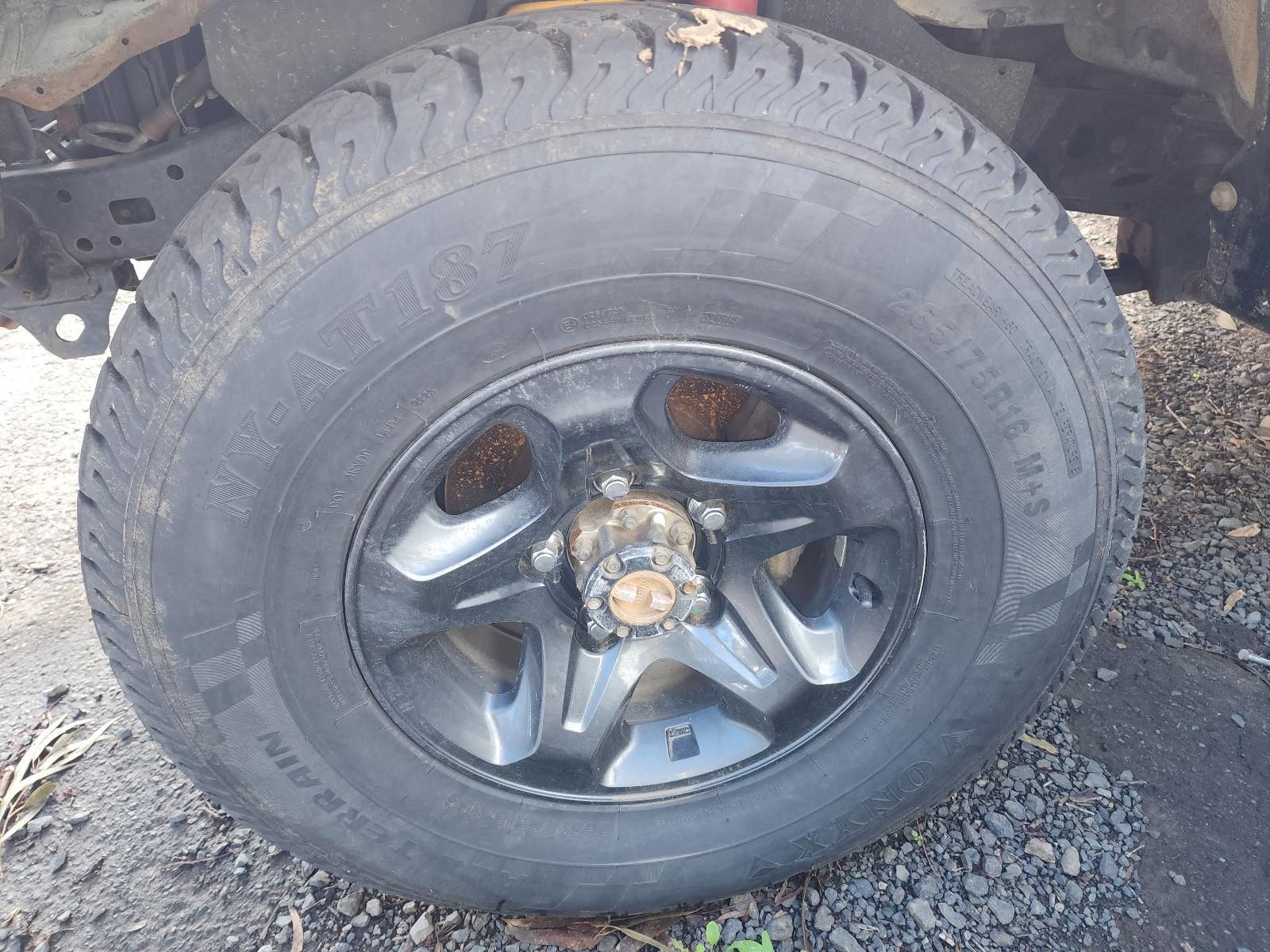 Close-up of a Car Tire With a Black Wheel Rim on Gravel — South West 4WD Wreckers In Harristown, QLD
