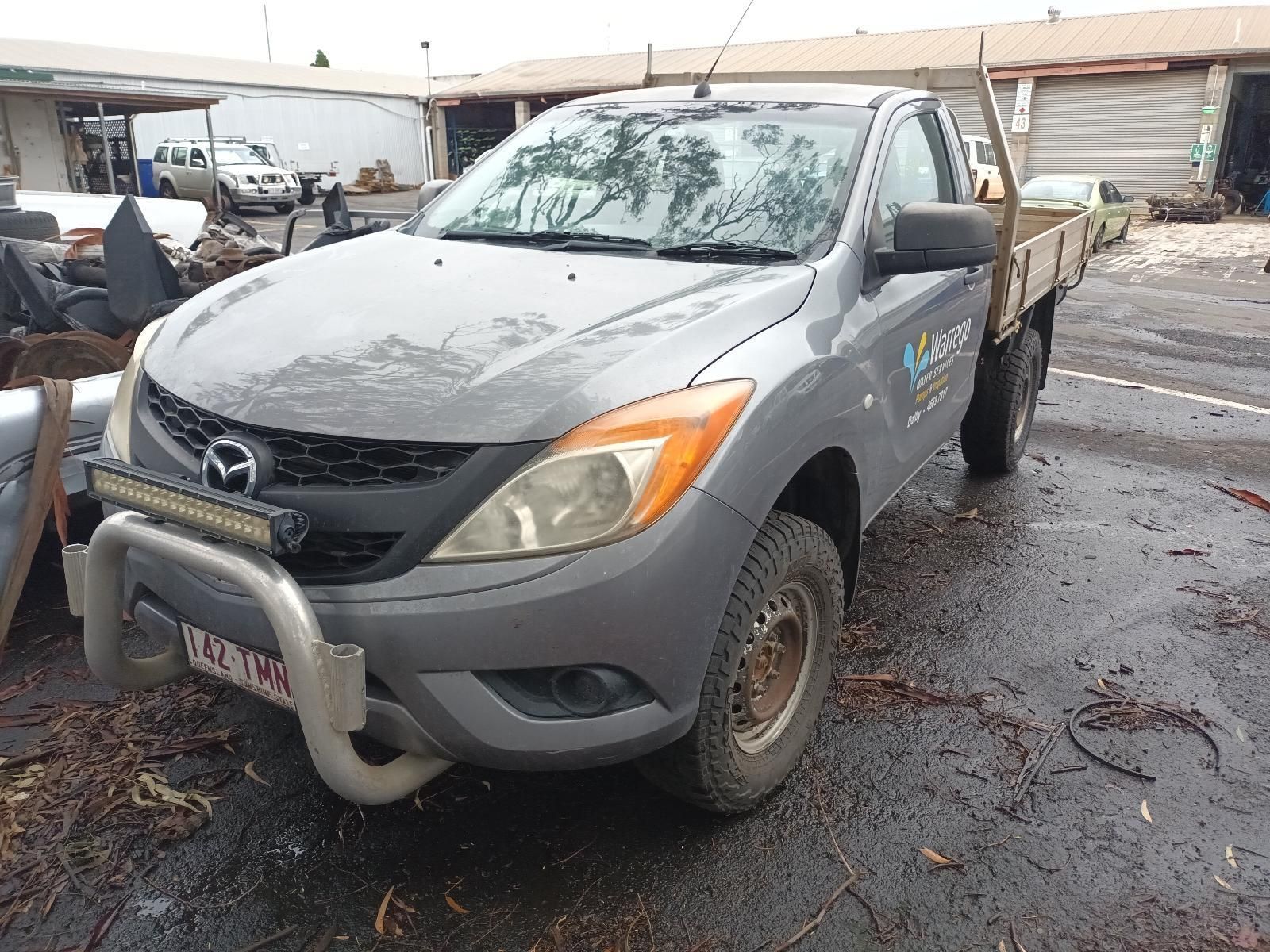 A Gray Truck With a Tray on the Back is Parked in a Lot — South West 4WD Wreckers In Brisbane, QLD