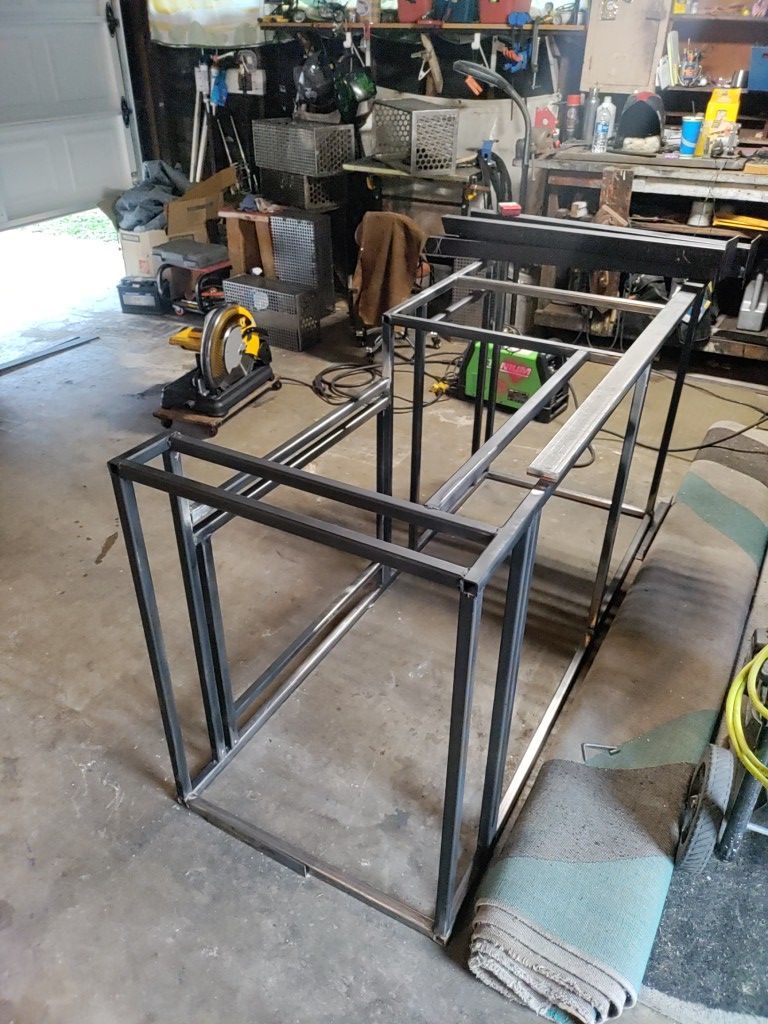Welded steel frames in a garage workspace, potentially for a table or shelving.