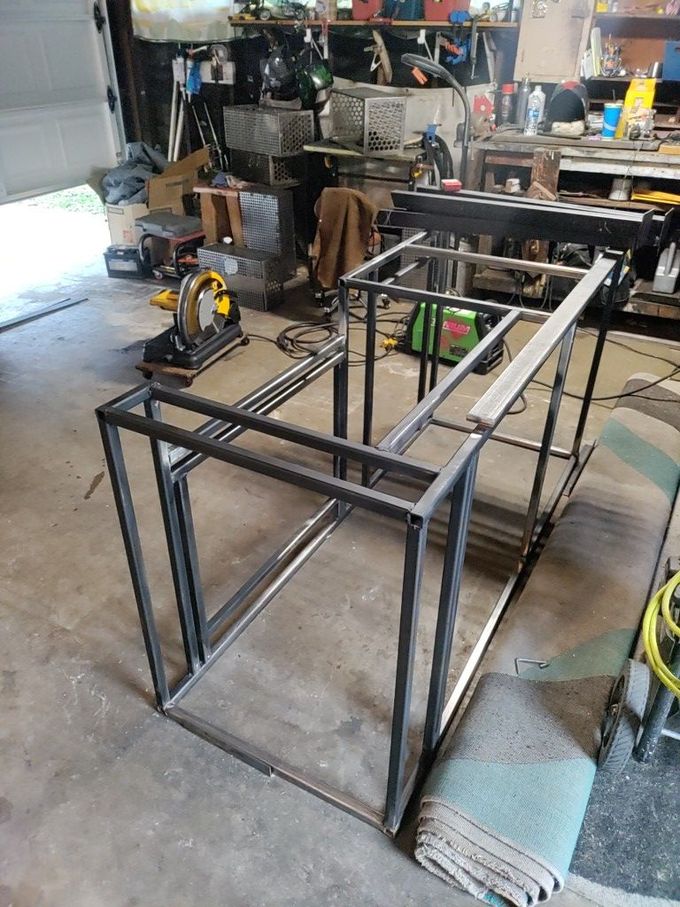 Welded steel frames in a garage workspace, potentially for a table or shelving.