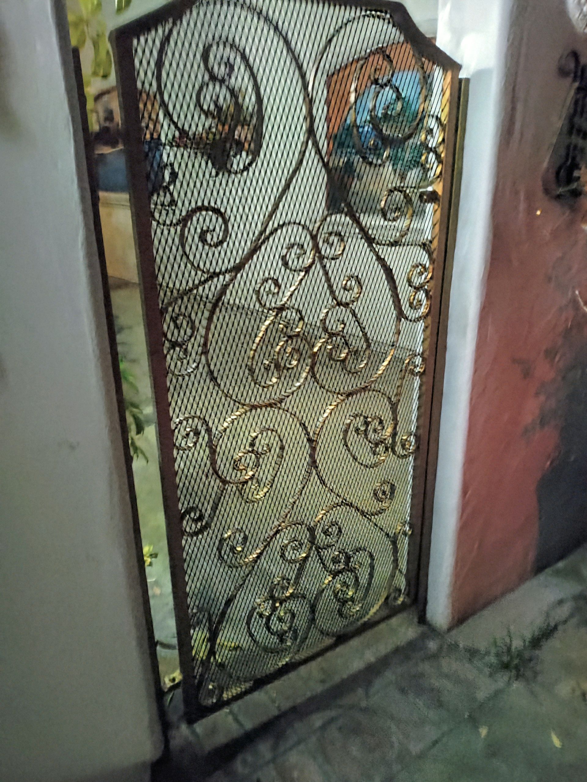 Ornate metal gate with swirling patterns.