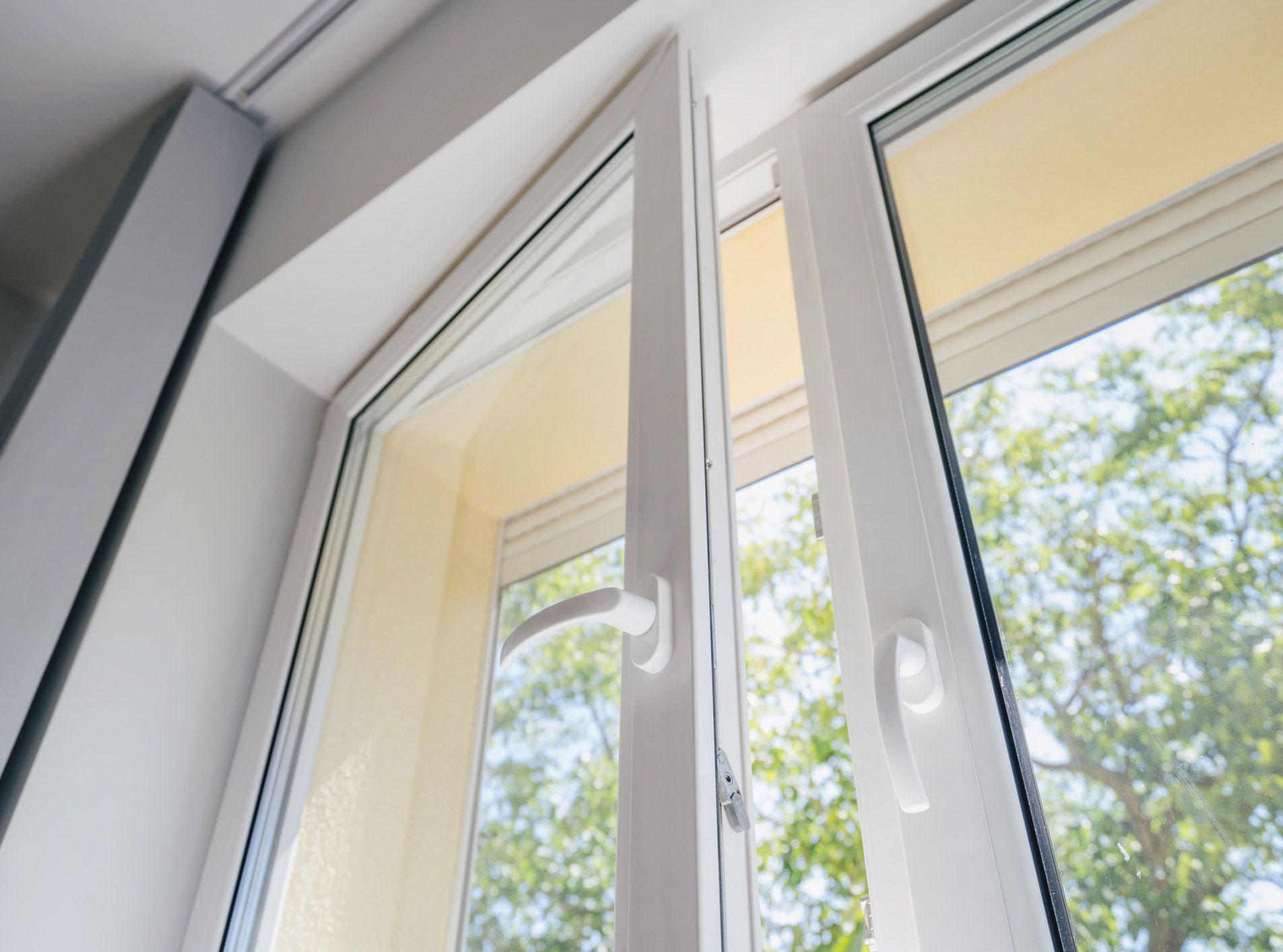 A close up of a white plastic window with the door open.