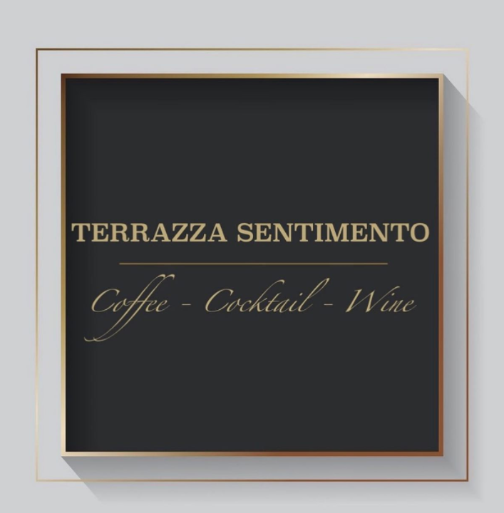 Un cartello quadrato nero con finiture dorate, recante le scritte dorate 
