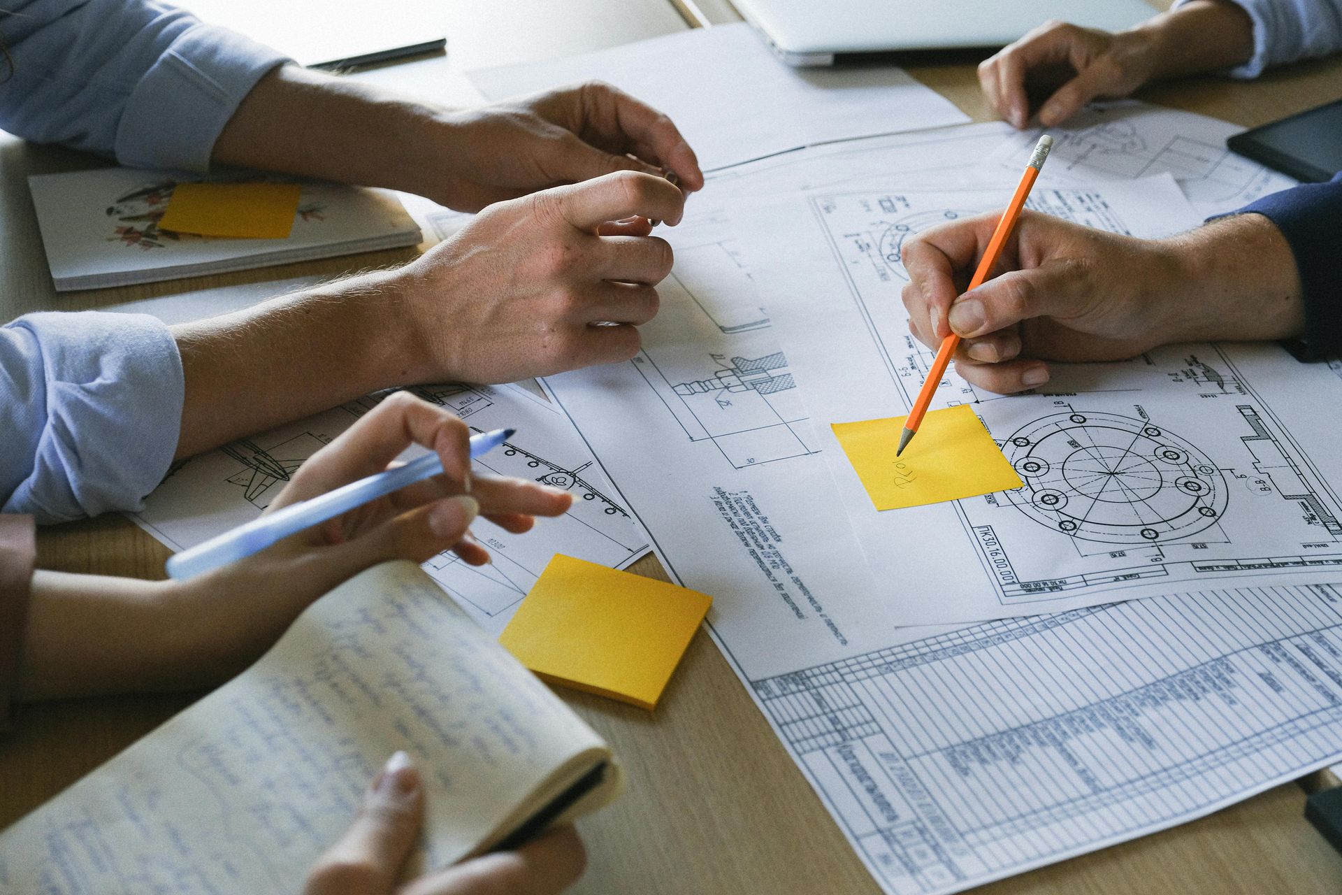 Hands Collaborating Around Blueprints, Notes, And Sticky Notes On A Table — GS Design & Drafting In Lismore, NSW