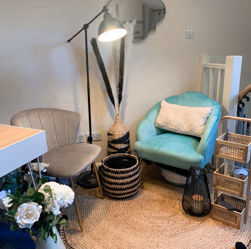 Cozy corner with turquoise chair, floor lamp, woven basket planter, and small shelves on a woven rug