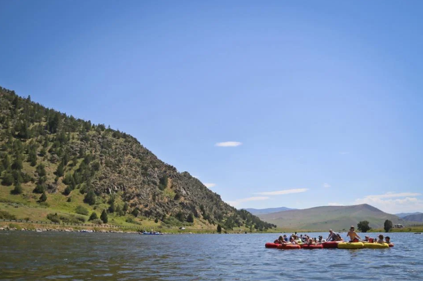 A group of people are floating on rafts on a lake.
