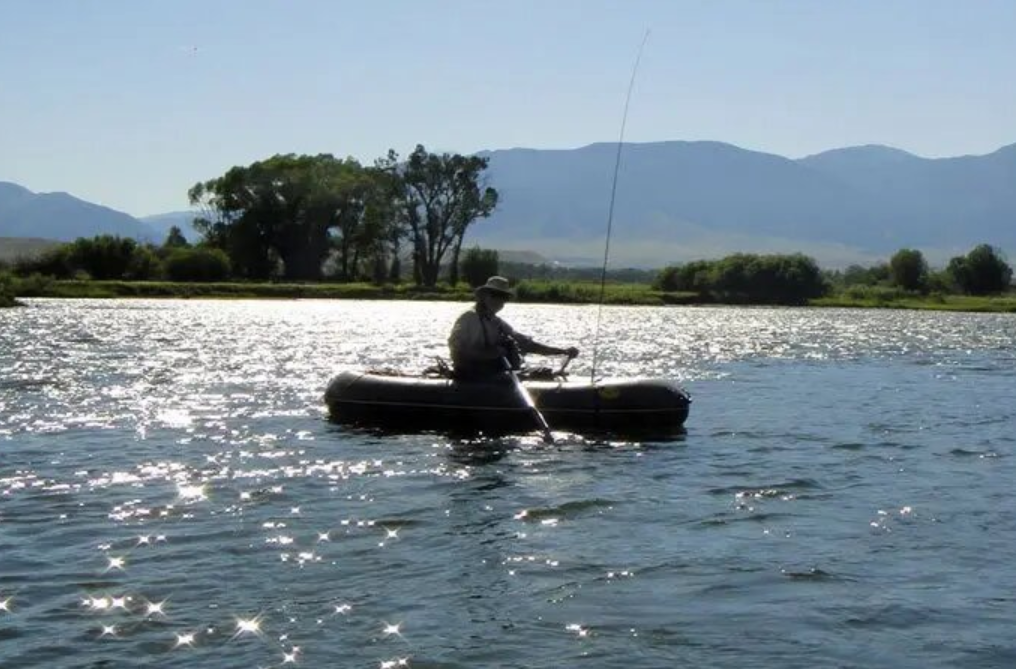 A man in a boat is fishing in a river