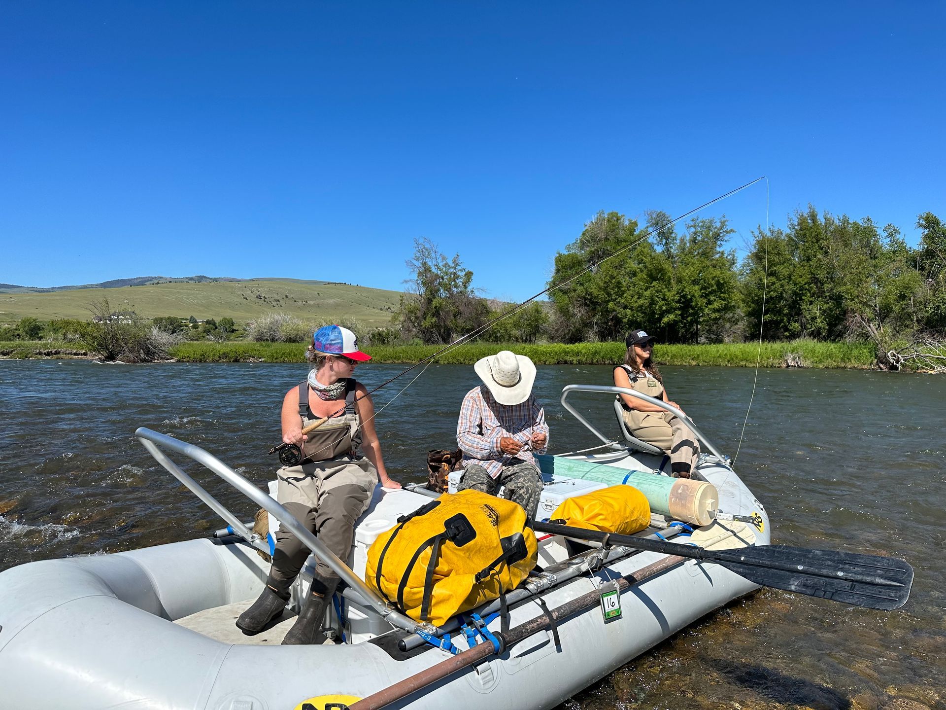 A group of people are sitting in a raft on a river.