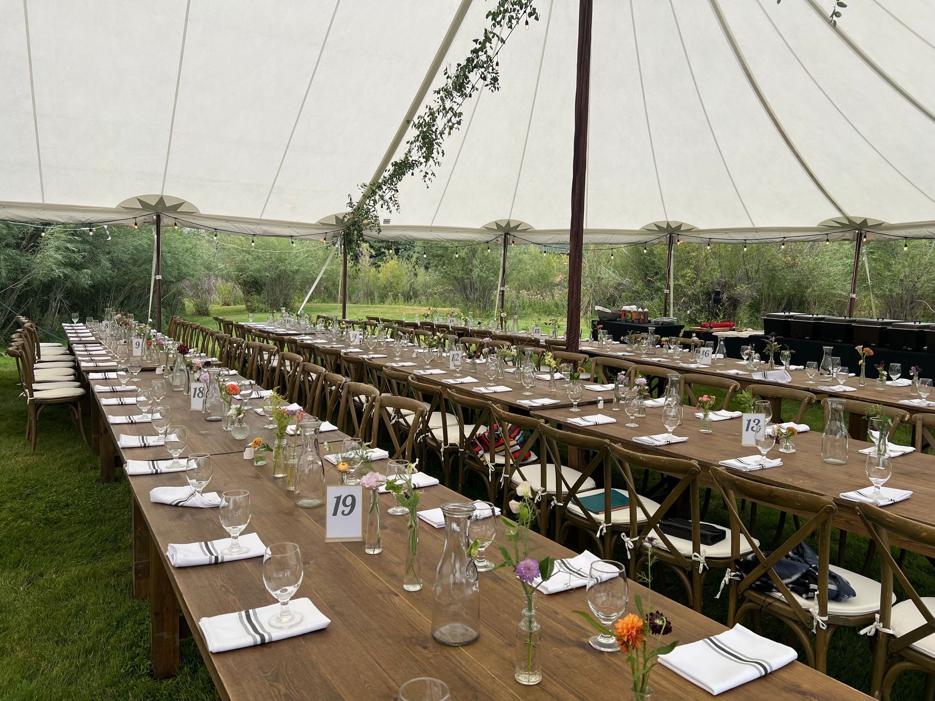 Outdoor venue with tent and dinner setting