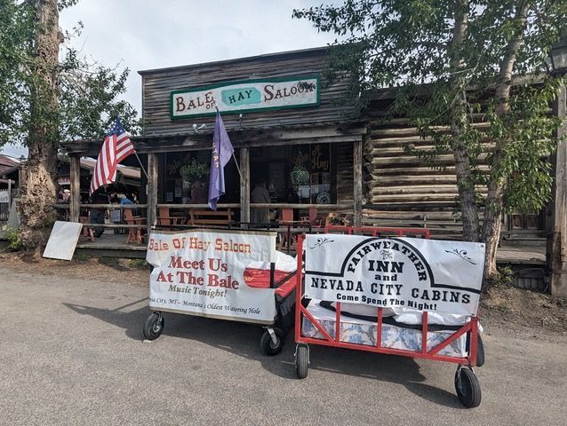 Two wagons are parked in front of a saloon.