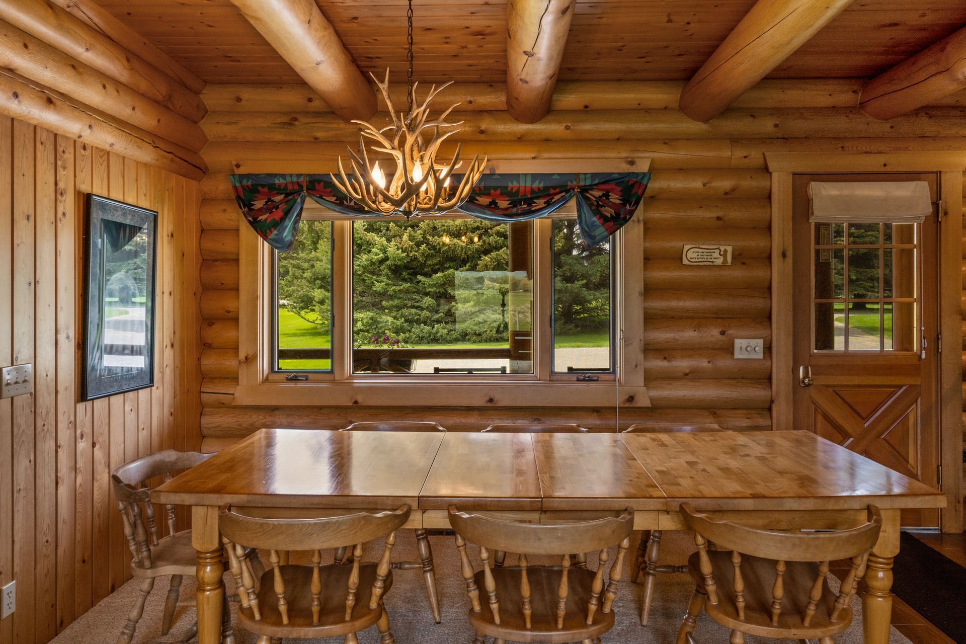 A dining room in a log cabin with a table and chairs