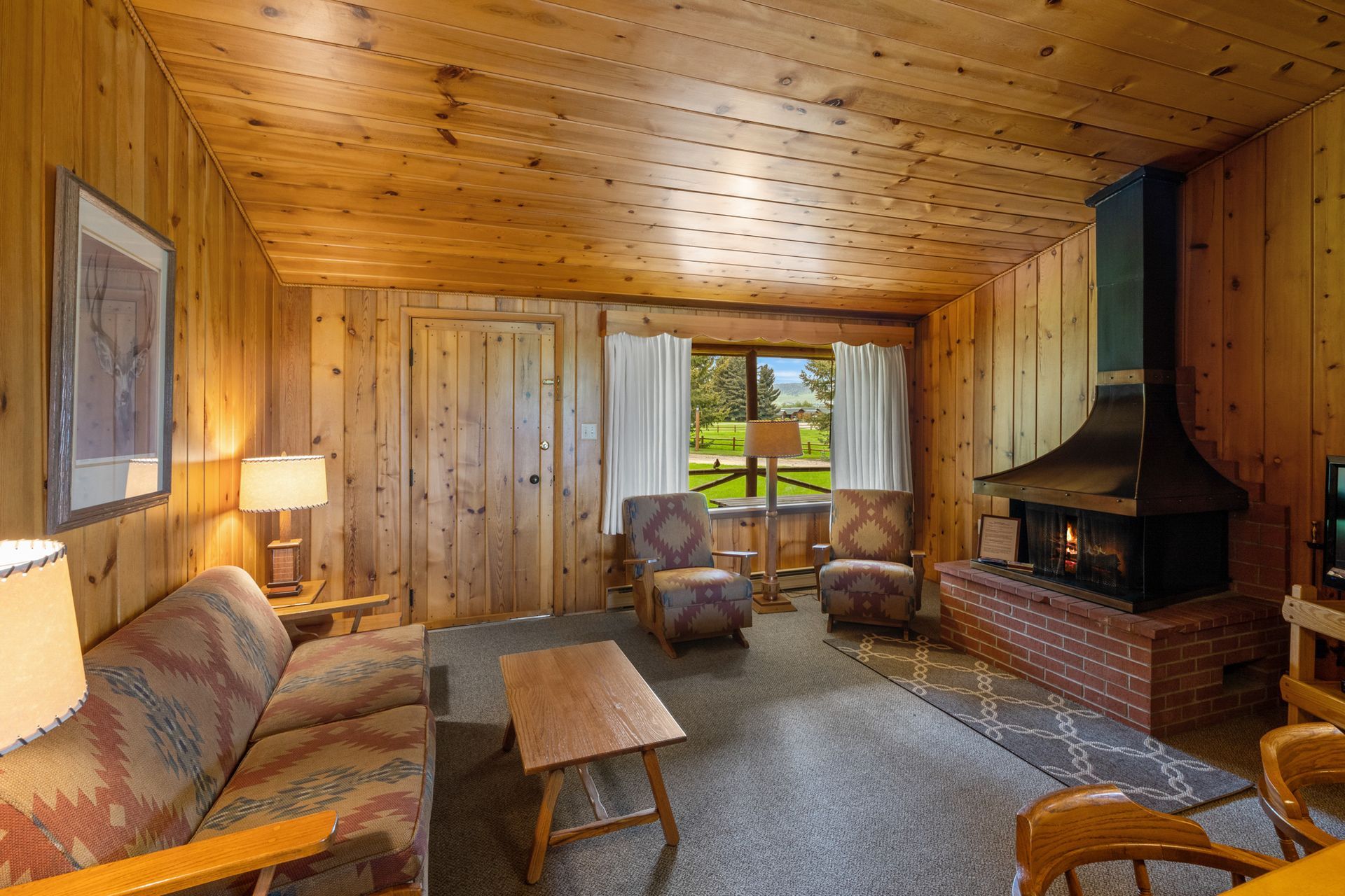 A living room with a couch , chairs , coffee table and fireplace.