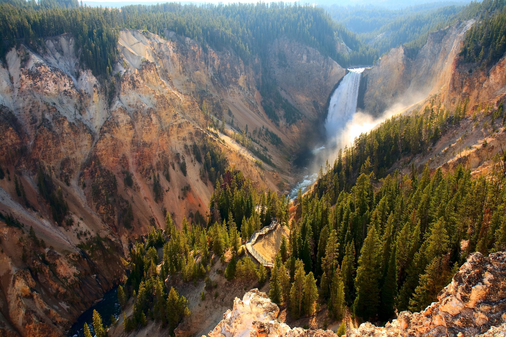 A waterfall in the middle of a canyon surrounded by trees